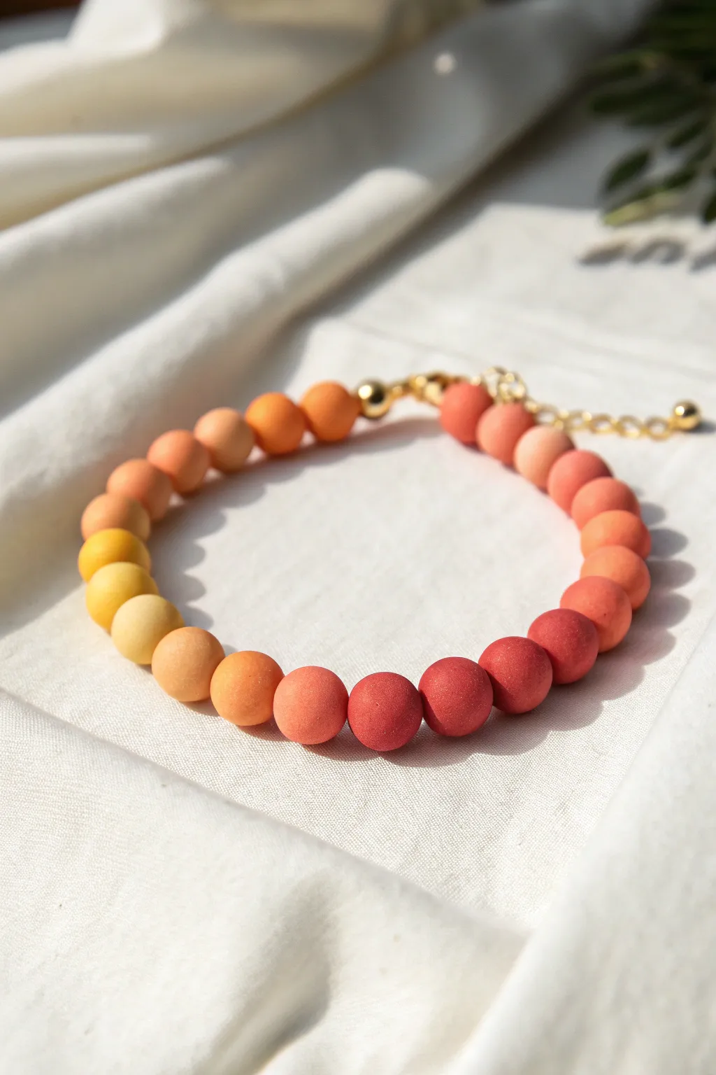 Sunset Fade ombre clay bead bracelet from coral to peach to pale yellow, minimal and boho