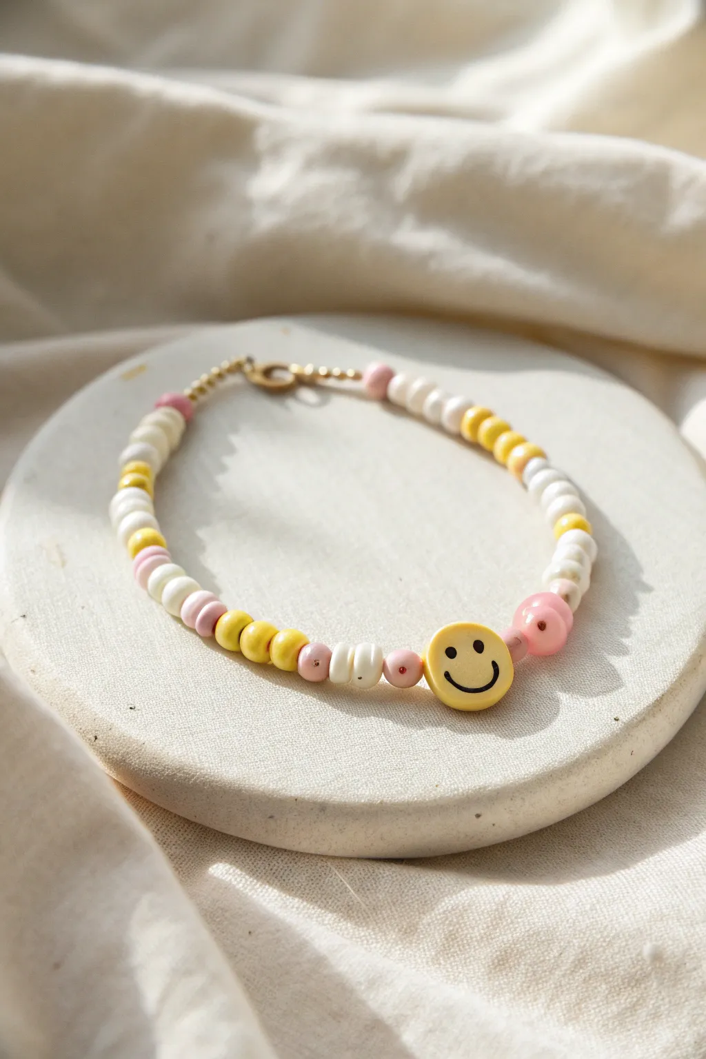 Sunny smiley center clay bead bracelet in pastel yellow, white, and a hint of blush pink