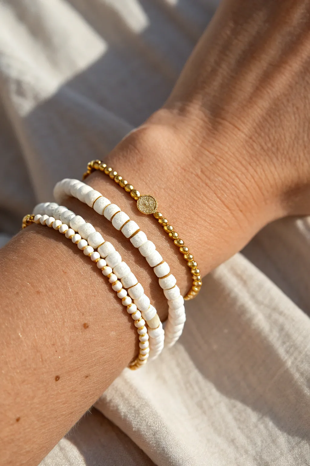 White clay disc beads with gold spacers make a clean, modern friendship bracelet stack.