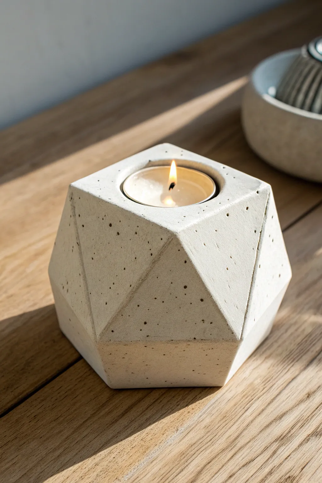 Chunky geometric clay tea light holder with crisp edges and a cozy, warm candle glow