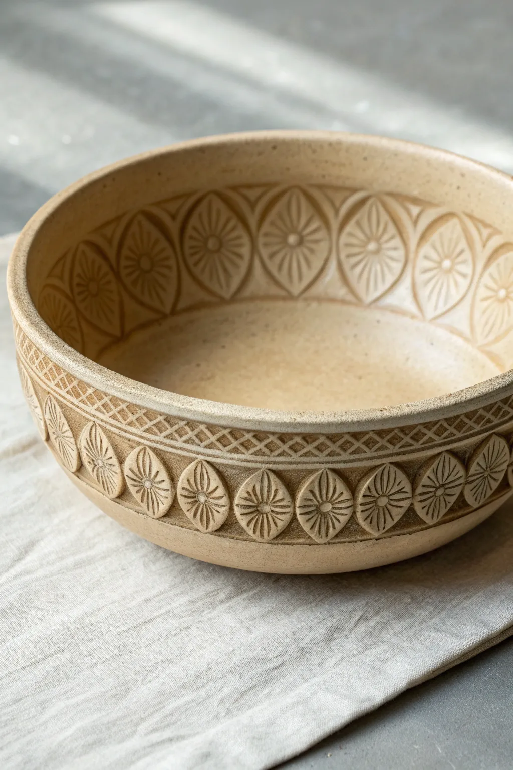 Shallow carved bowl with chunky petal medallions, simple relief details that glow in side light.