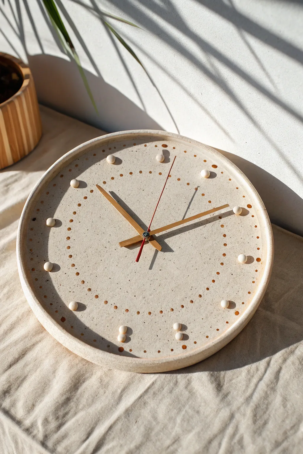 Minimal clay wall clock with raised dot and dash markers in warm terracotta contrast
