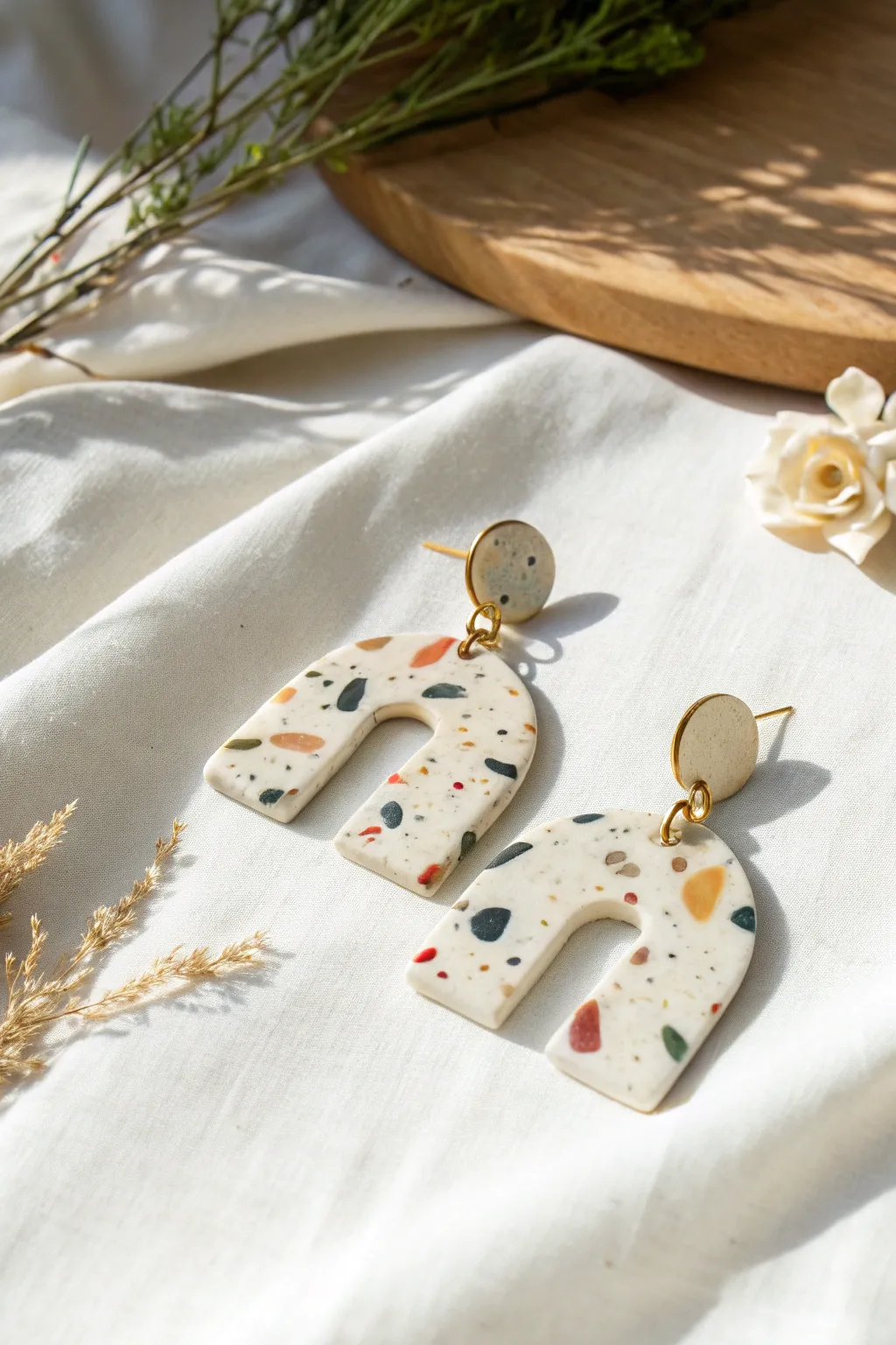 Terrazzo speckle clay earrings in arch and rounded rectangle shapes, minimalist flatlay.