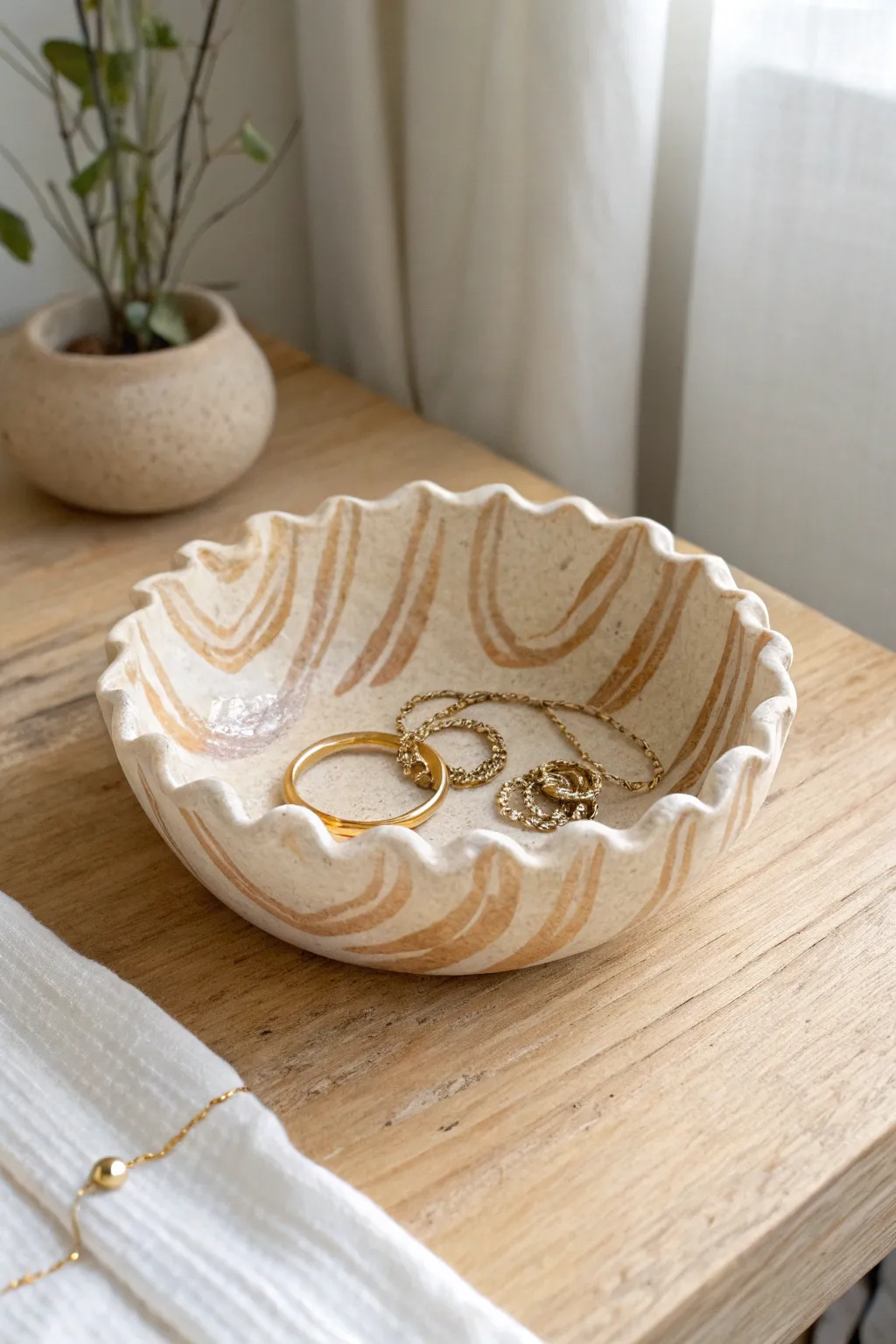 Wavy handmade catch-all bowl with soft stripes, perfect for earrings and delicate chains