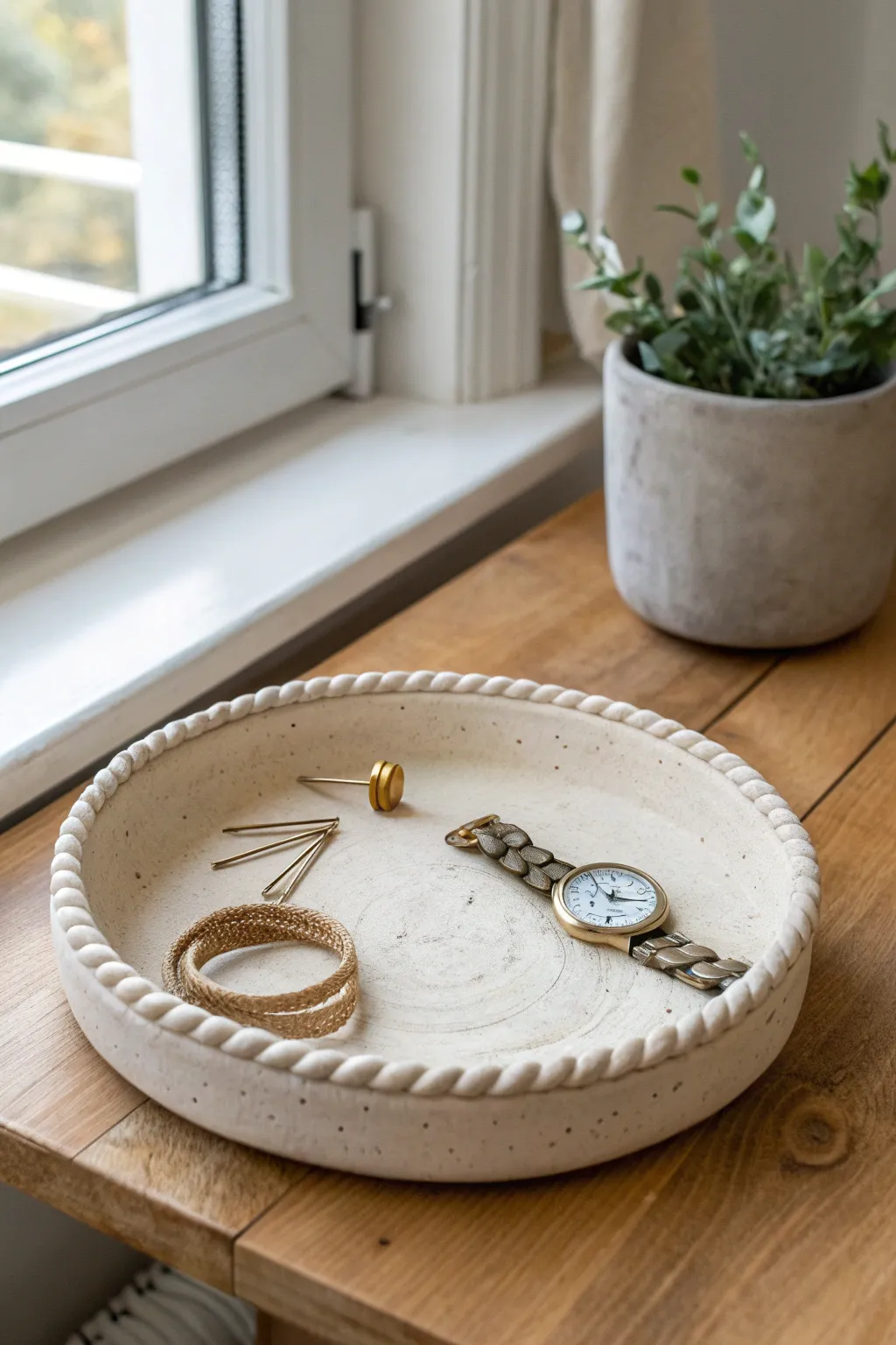 Coil-rimmed clay tray with raised border, styled to hold a watch and hair pins beautifully.