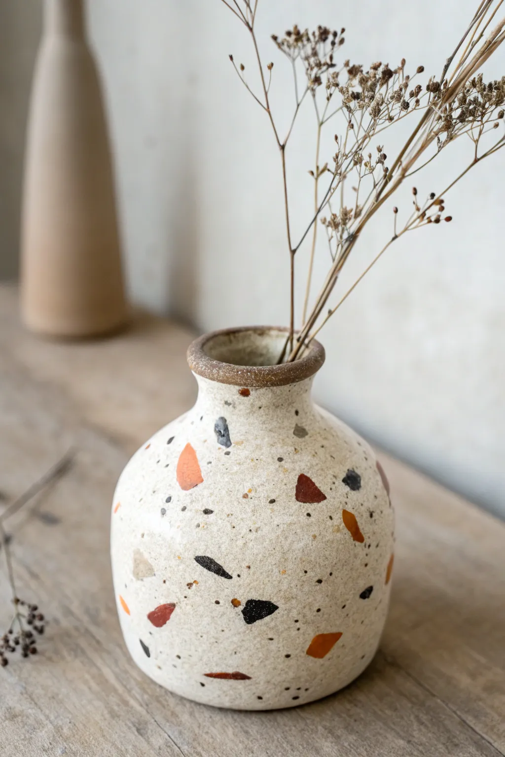 Simple speckled terrazzo bud vase idea with a soft matte finish and delicate dried sprigs