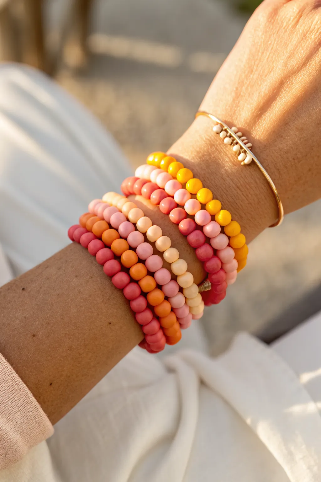 Sunset Gradient Stack: hot pink to sunny yellow clay bracelets glowing in golden-hour light