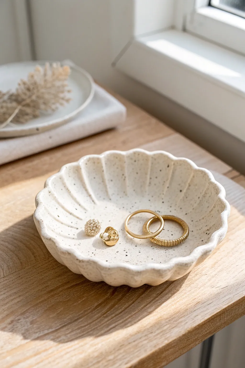 Scalloped rim drape dish in soft matte glaze, styled with rings for a minimal boho look.