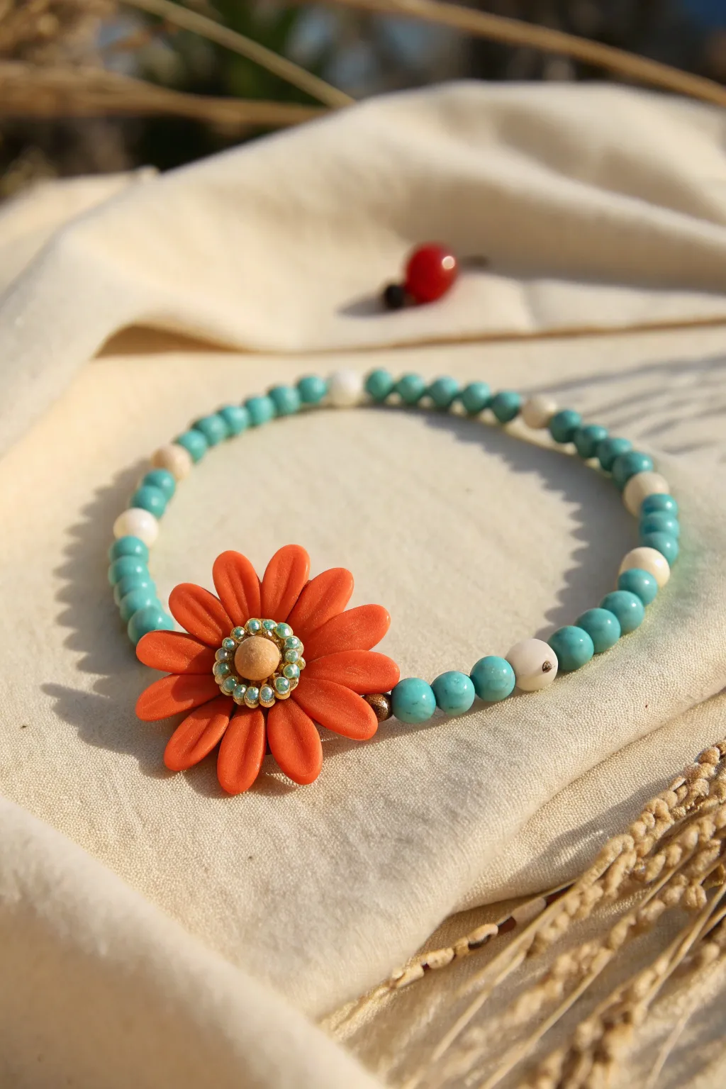 Orange flower focal bead meets teal heishi beads in sunny light for a bold color pop