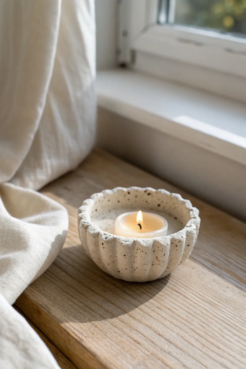 Thumb-pressed tea light holder with scalloped rim texture, styled in soft Nordic-boho neutrals