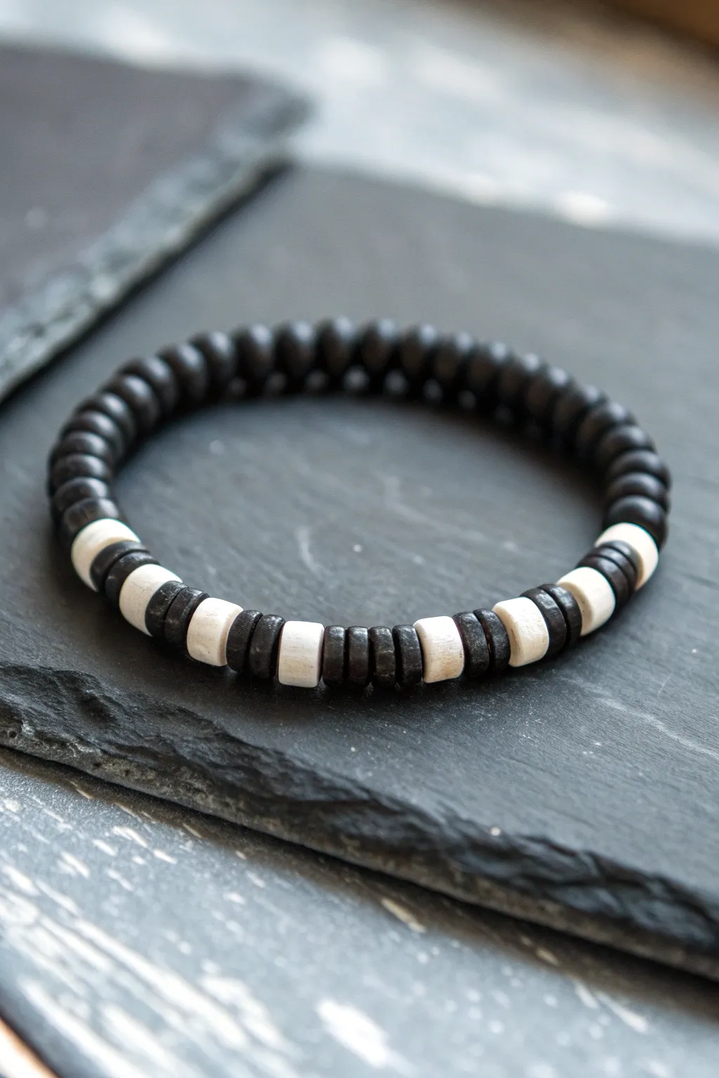 Bold black heishi beads with crisp white blocks on dark stone for a clean modern look.