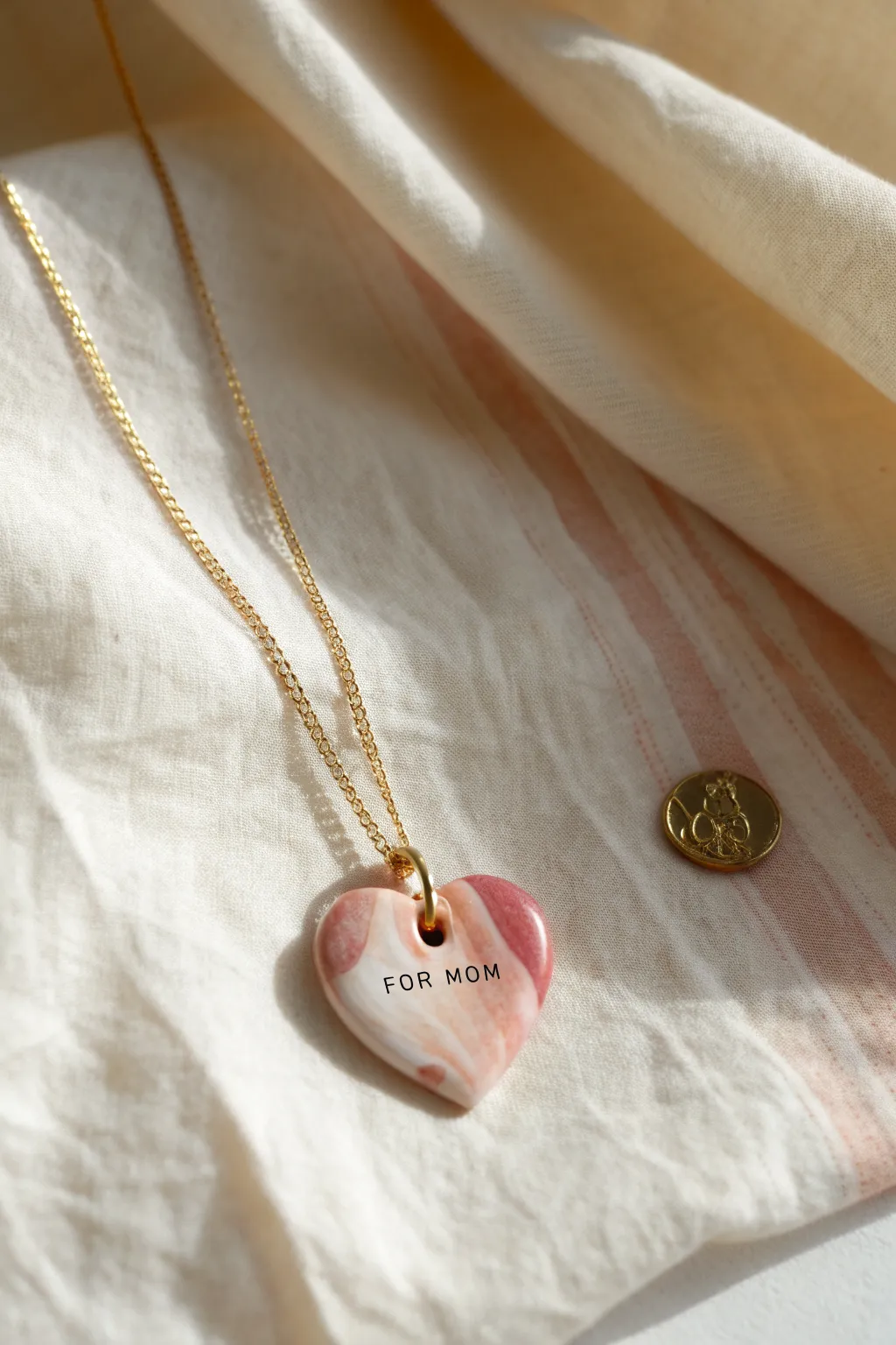 Glossy marbled clay heart necklace with a tiny For Mom tag, minimal and handmade-perfect.