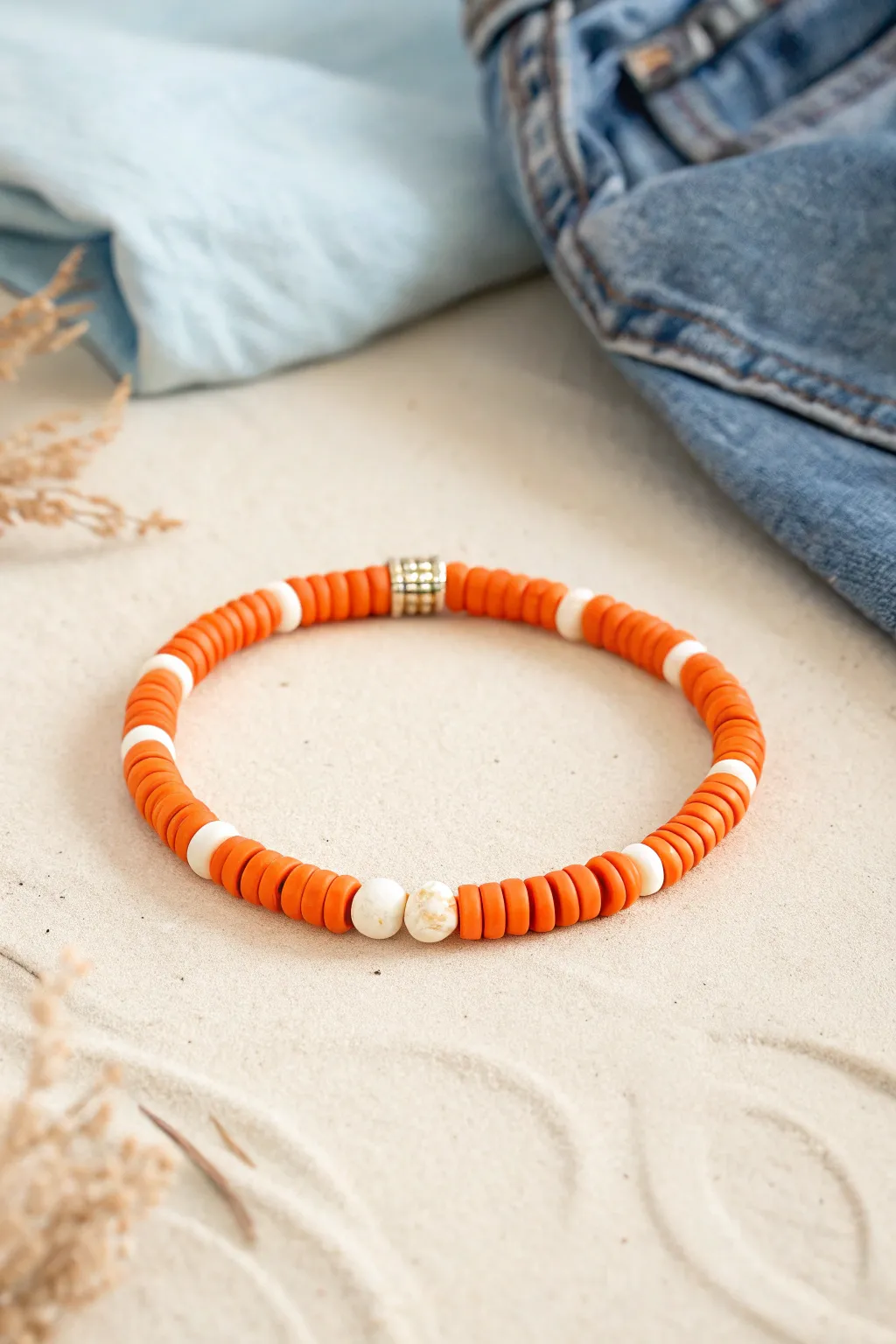 Orange color-block heishi bracelet with creamy breaks, minimalist boho vibes styled beside denim
