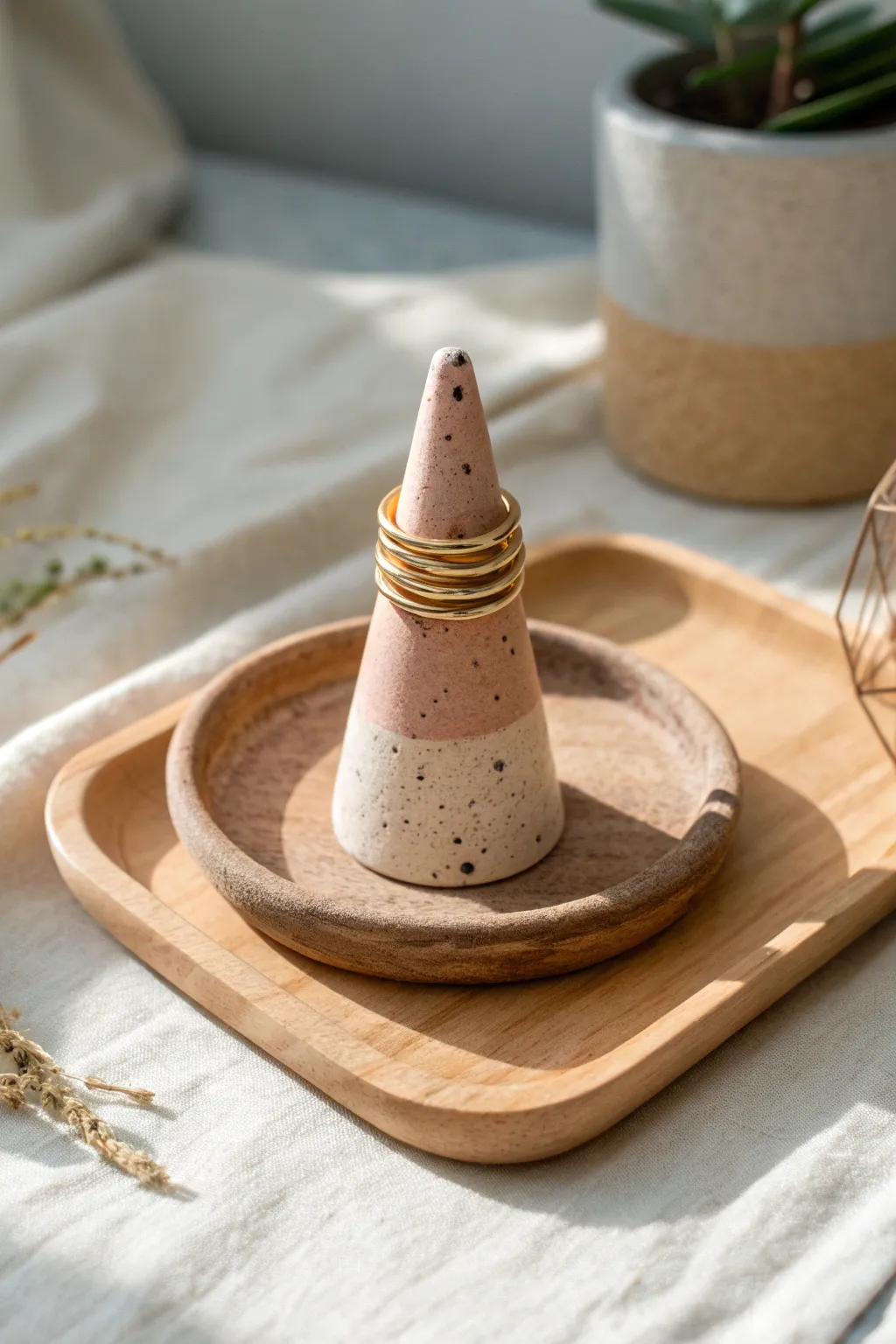 Minimal polymer clay ring cone in blush and sand tones, softly lit with a few stacked rings.