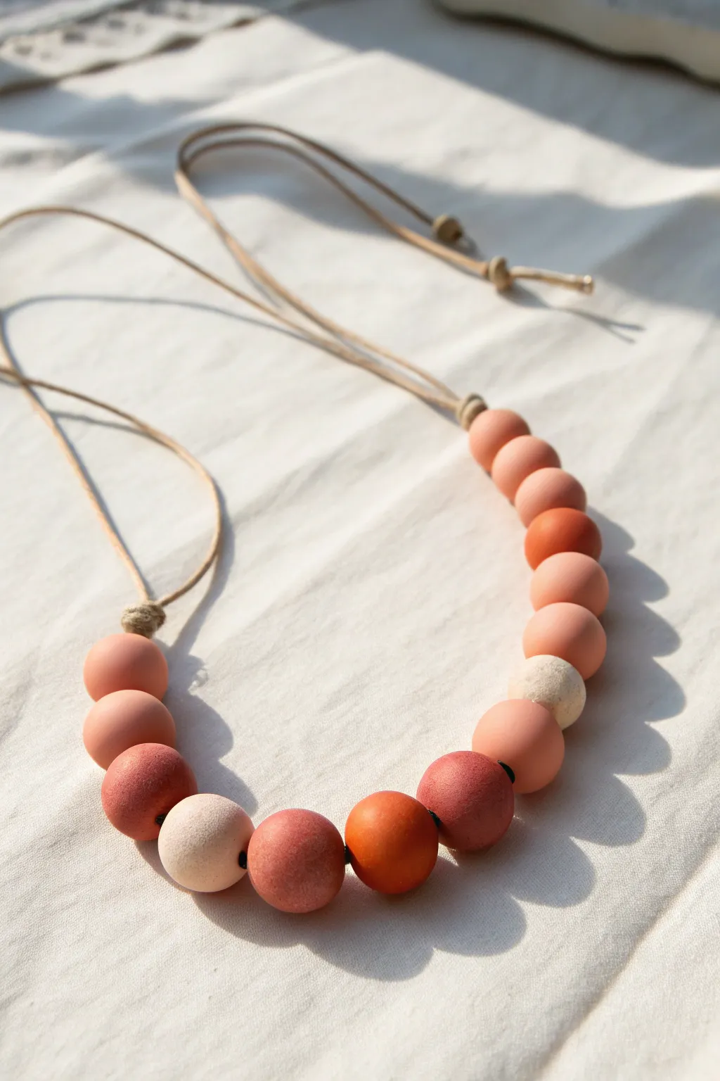 Soft ombre polymer clay beads from blush to terracotta for a minimalist boho statement necklace.