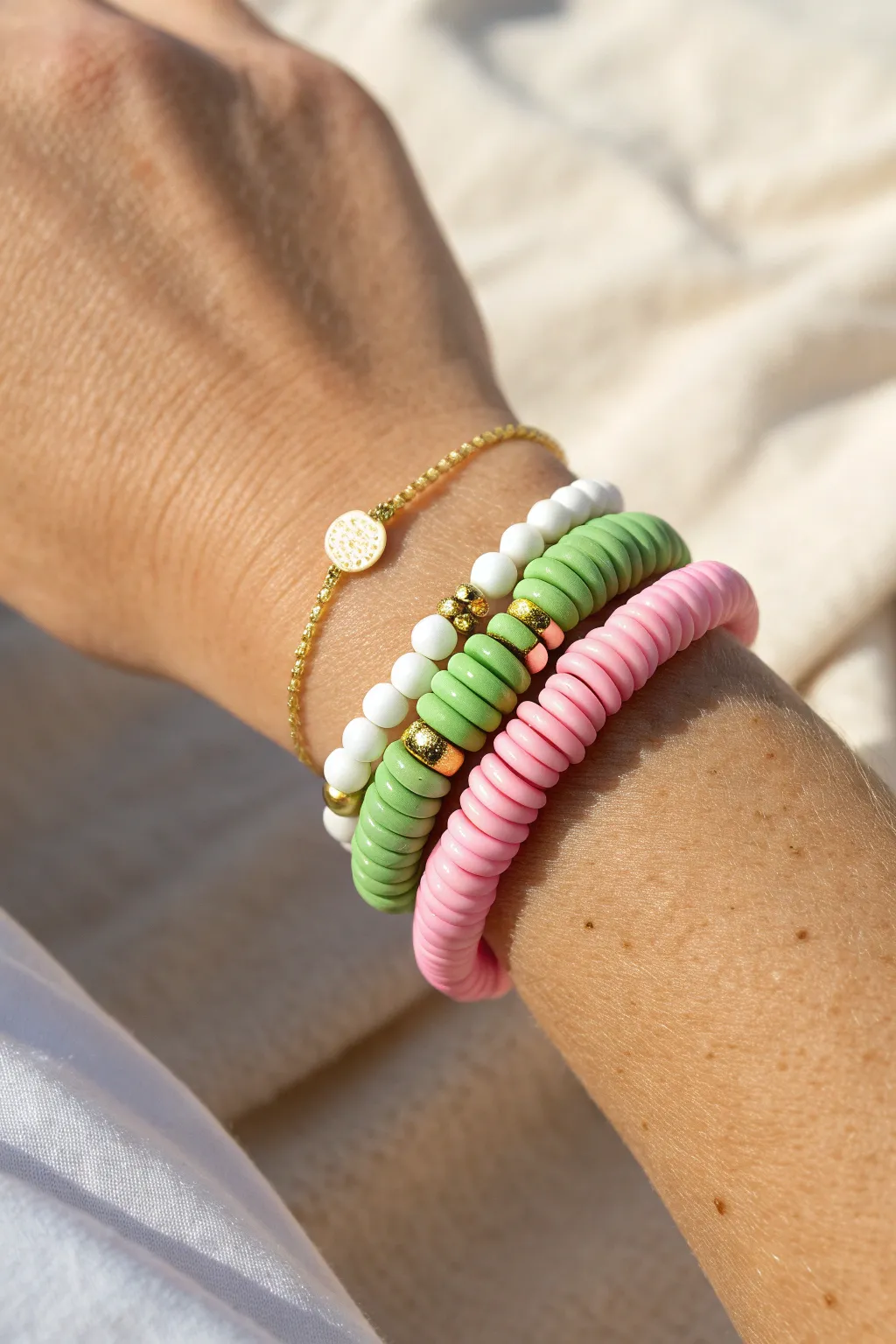 Pink and green preppy heishi bracelets with white accents for an easy, summery pop combo.