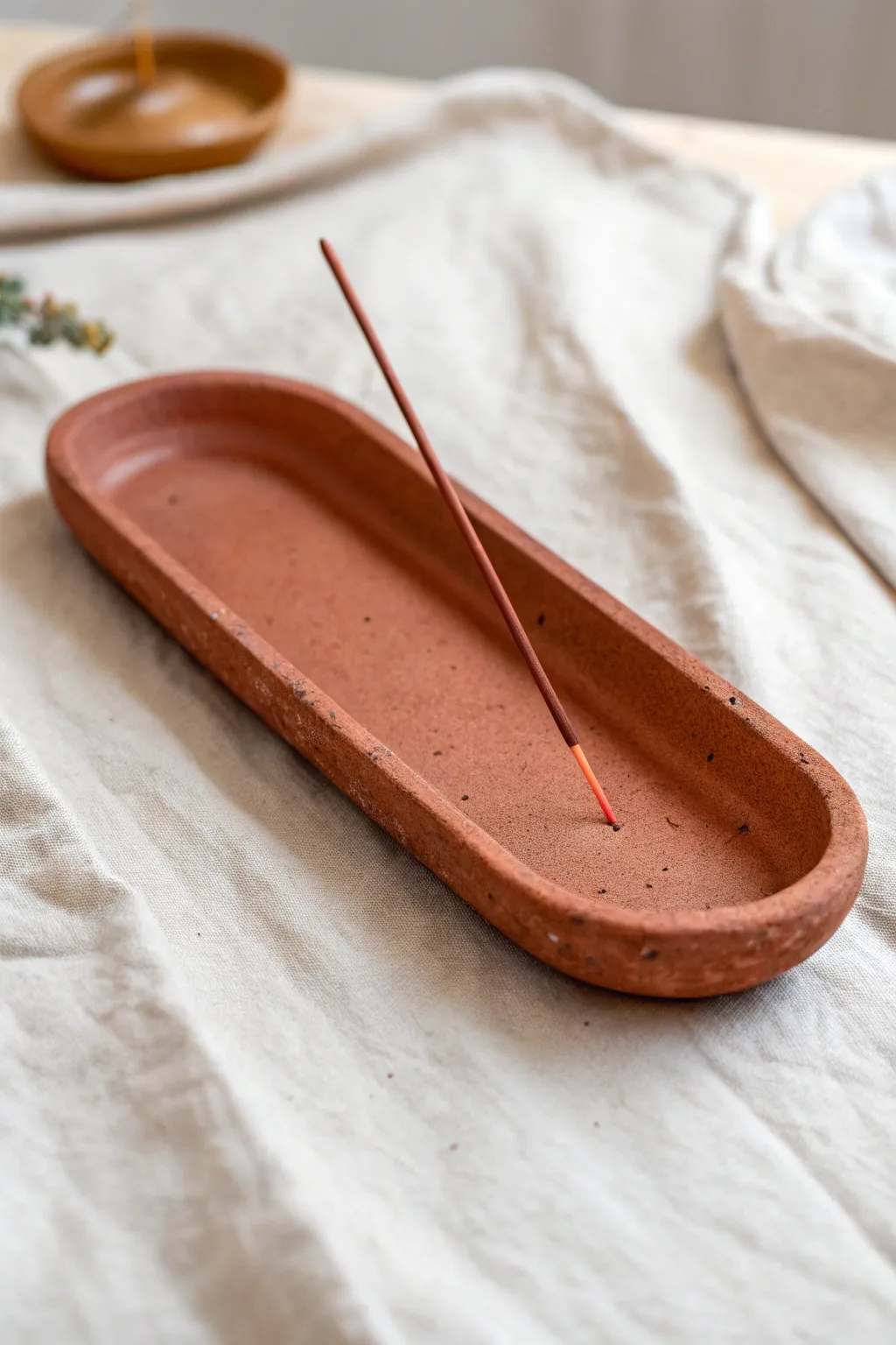 Minimal red clay incense tray with a simple curve and warm terracotta contrast