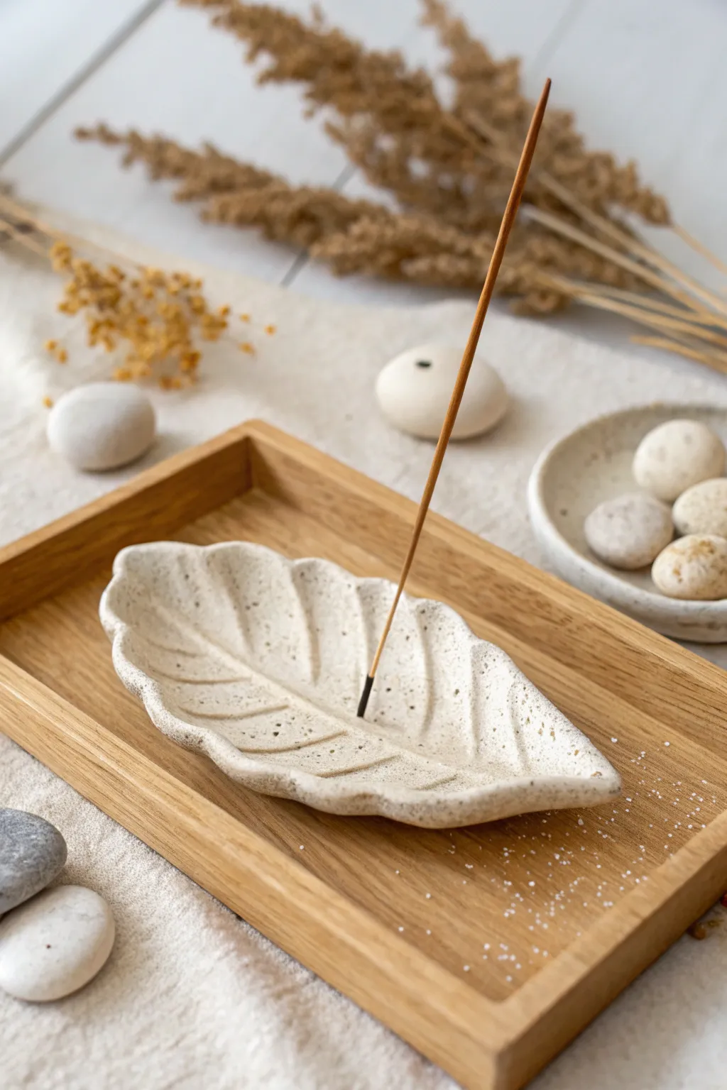 Minimal leaf-shaped clay incense holder styled on a tray for calm, spa-like decor