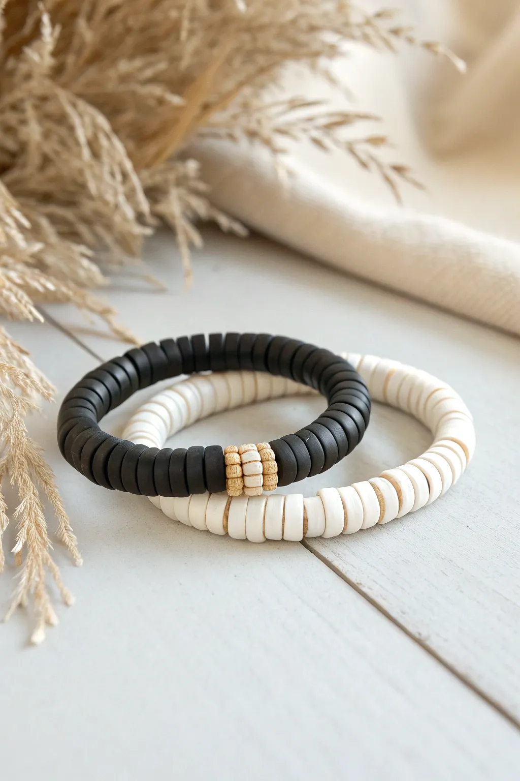 Clean monochrome heishi stack: matte black and white clay bead bracelets, simple and chic