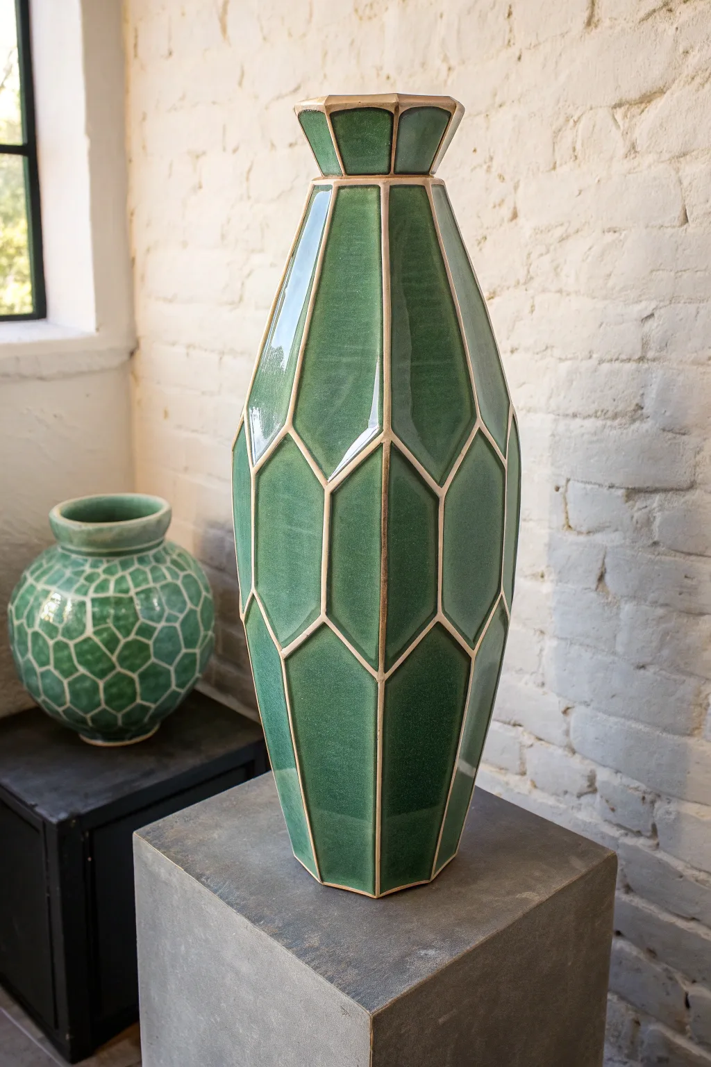Faceted slab vase in glossy sage glaze, minimal Scandinavian styling with sculptural light play.