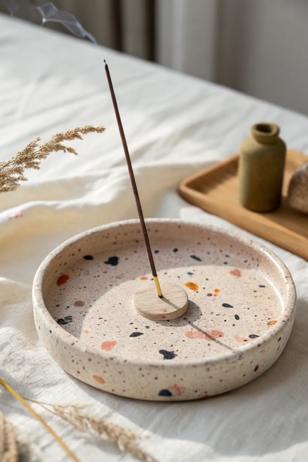 Speckled terrazzo air dry clay dish with angled incense hole in a clean Scandi boho scene.