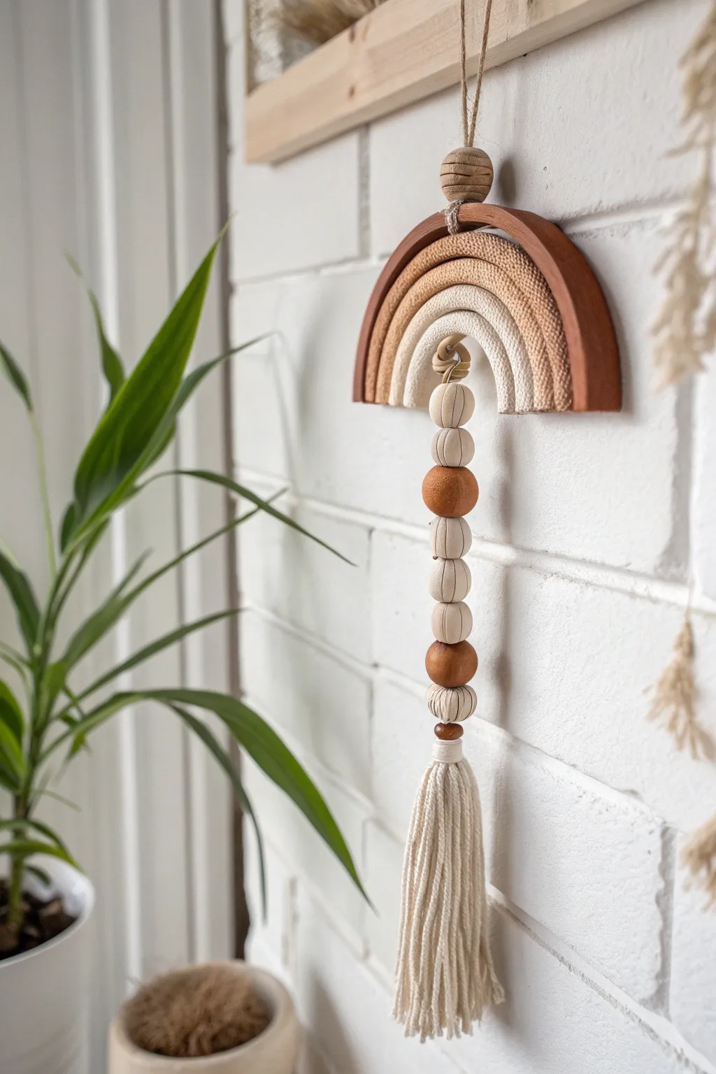 Warm neutral clay bead wall hanging with a cotton tassel, minimalist boho style