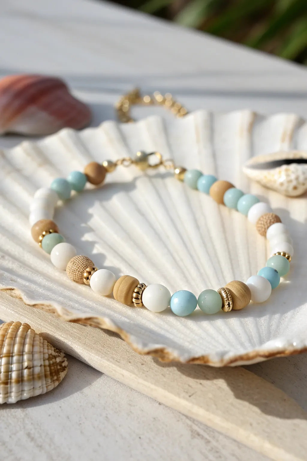 Cowrie shell focal bracelet with soft clay beads in white, sand, and pale blue coastal tones