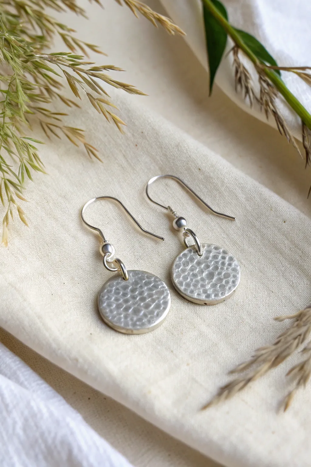 Simple silver clay disc dangle earrings with soft texture and clean minimalist contrast