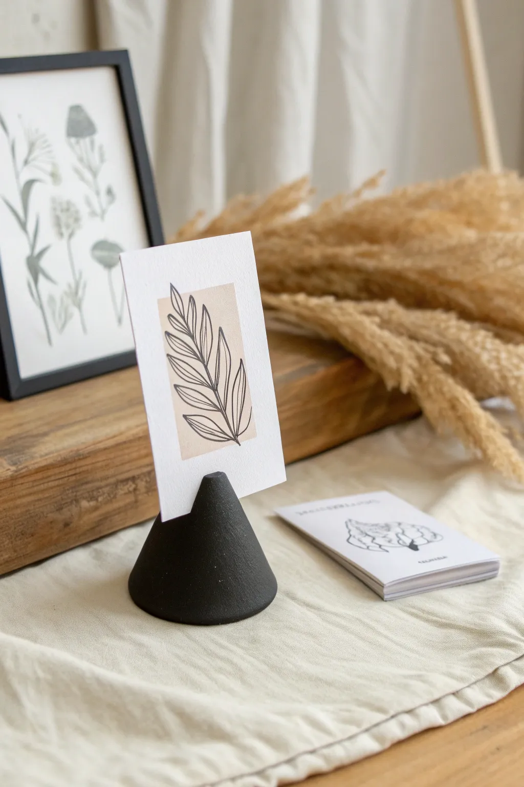 Minimal black clay photo stand with crisp cards, Scandinavian calm with a boho touch.