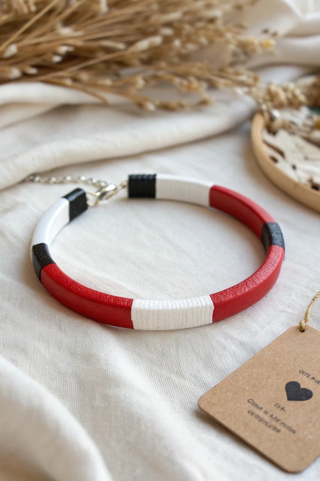 Santa hat color-block clay bracelet in red, white, and black on minimal linen styling