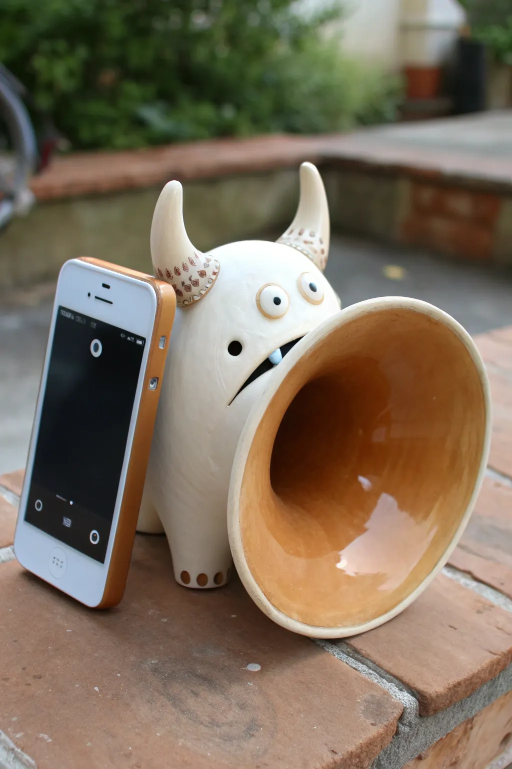 A playful wide-mouth monster horn that boosts your phone speaker with simple handmade charm