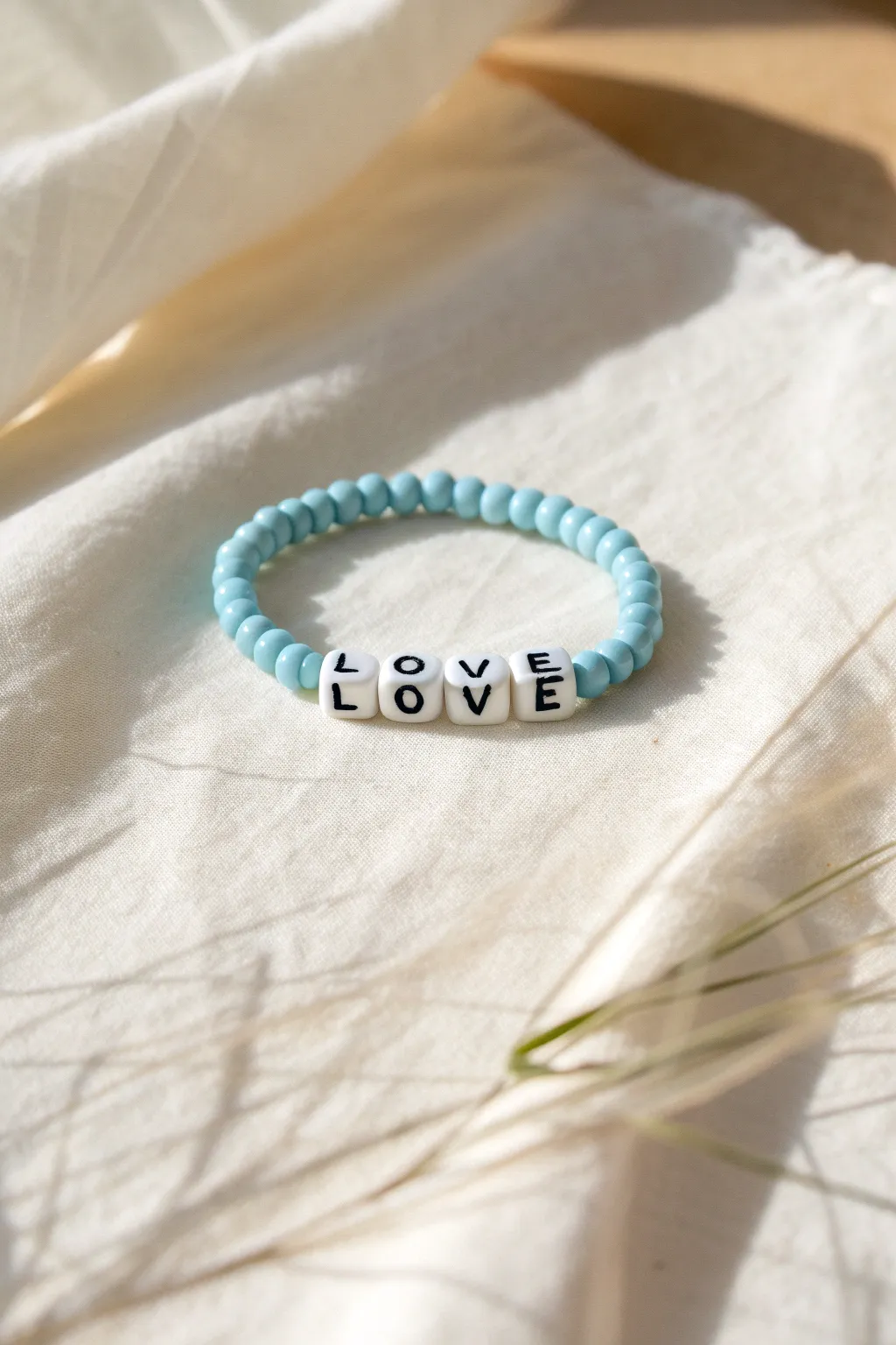 Sky blue heishi bracelet with crisp white letter beads for a simple, sweet beachy statement.