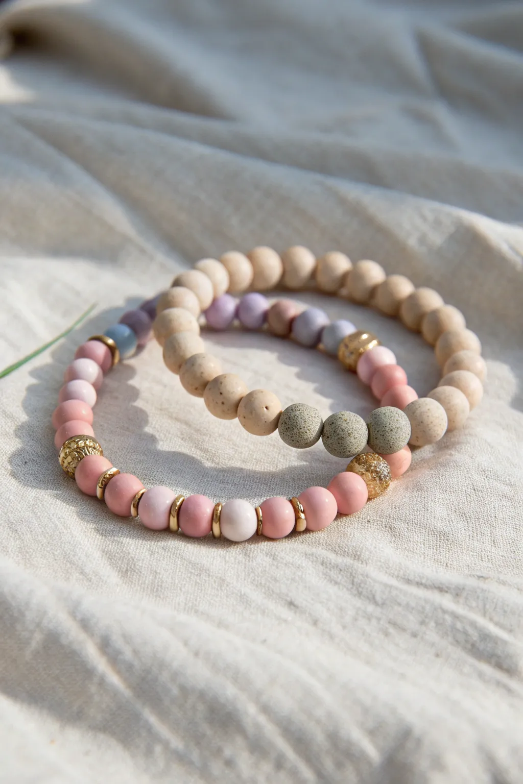 Neutral + pastel couple bracelets: soft blush accents with warm earthy clay beads, simple and modern.