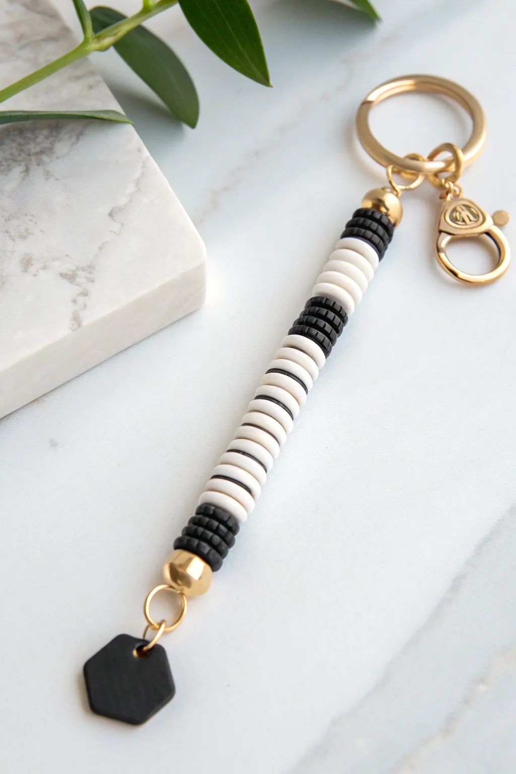 Minimal black-and-white heishi bead keychain with a sleek geometric charm and modern contrast.