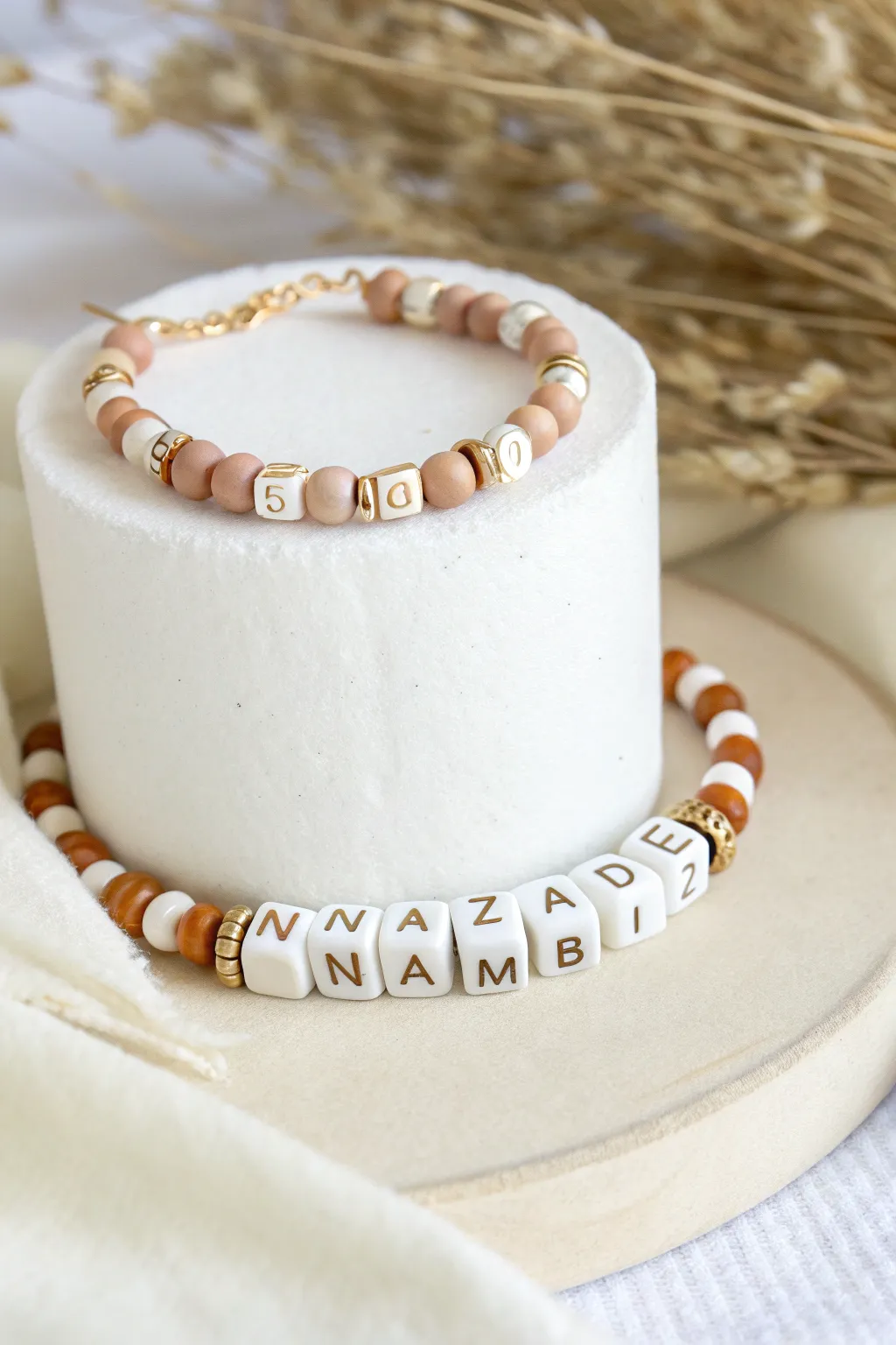 Personalized clay heishi and letter bead name bracelet in soft neutrals, minimalist boho styling.