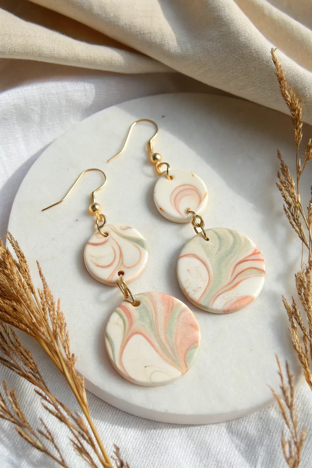 Soft marble swirl clay earrings in creamy tones with blush and sage for a calm modern look