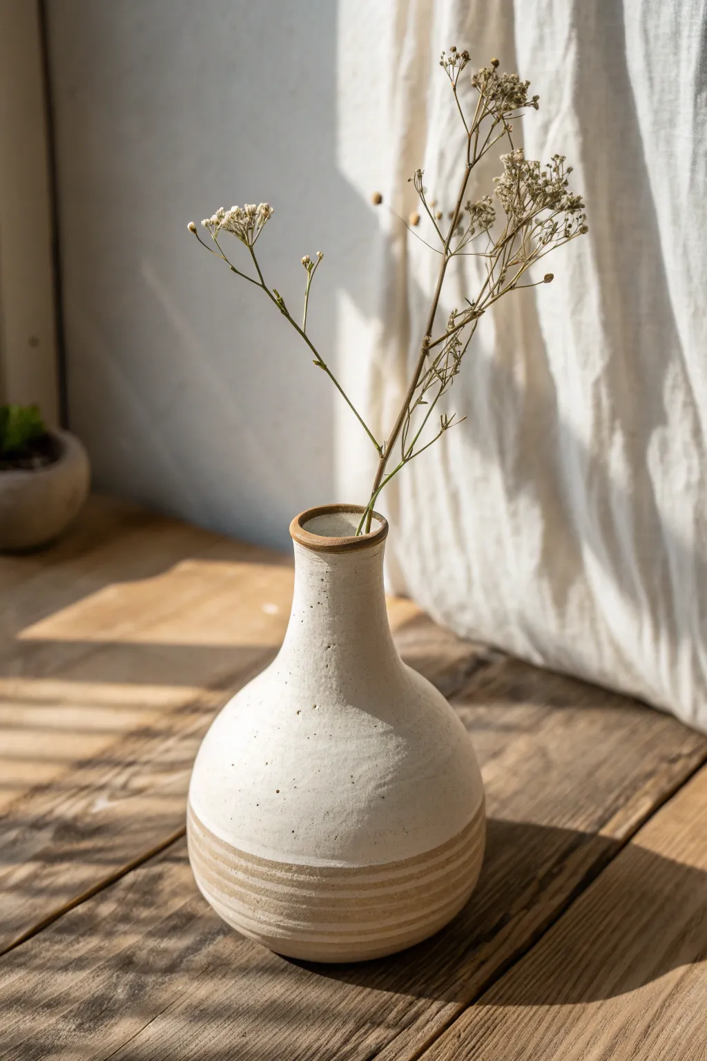 Minimal bud vase: matte clay body, glossy glaze detail, and one stem for calm functional art.