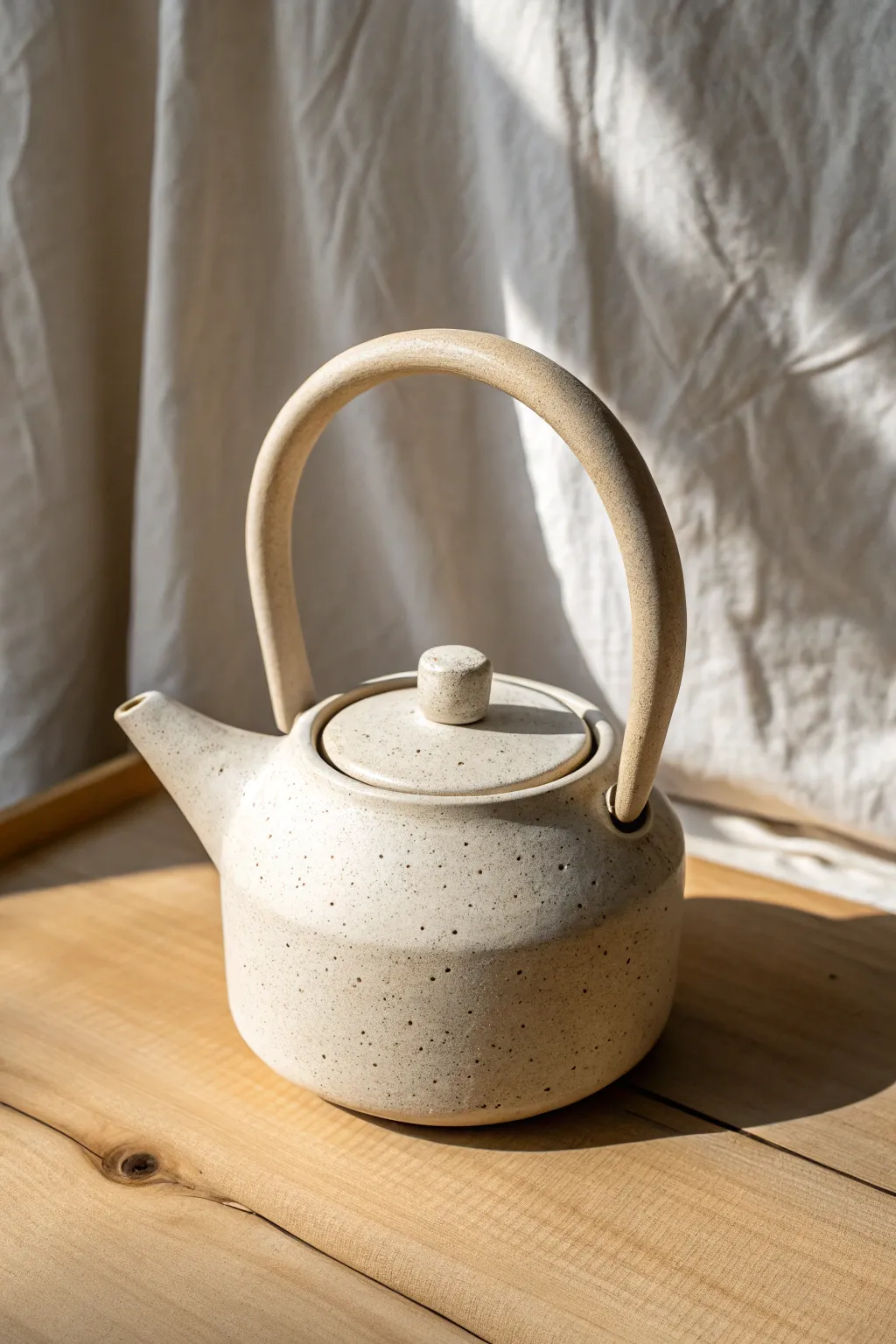 Modern loop-handle clay teapot idea with clean lines, warm texture, and minimalist contrast.