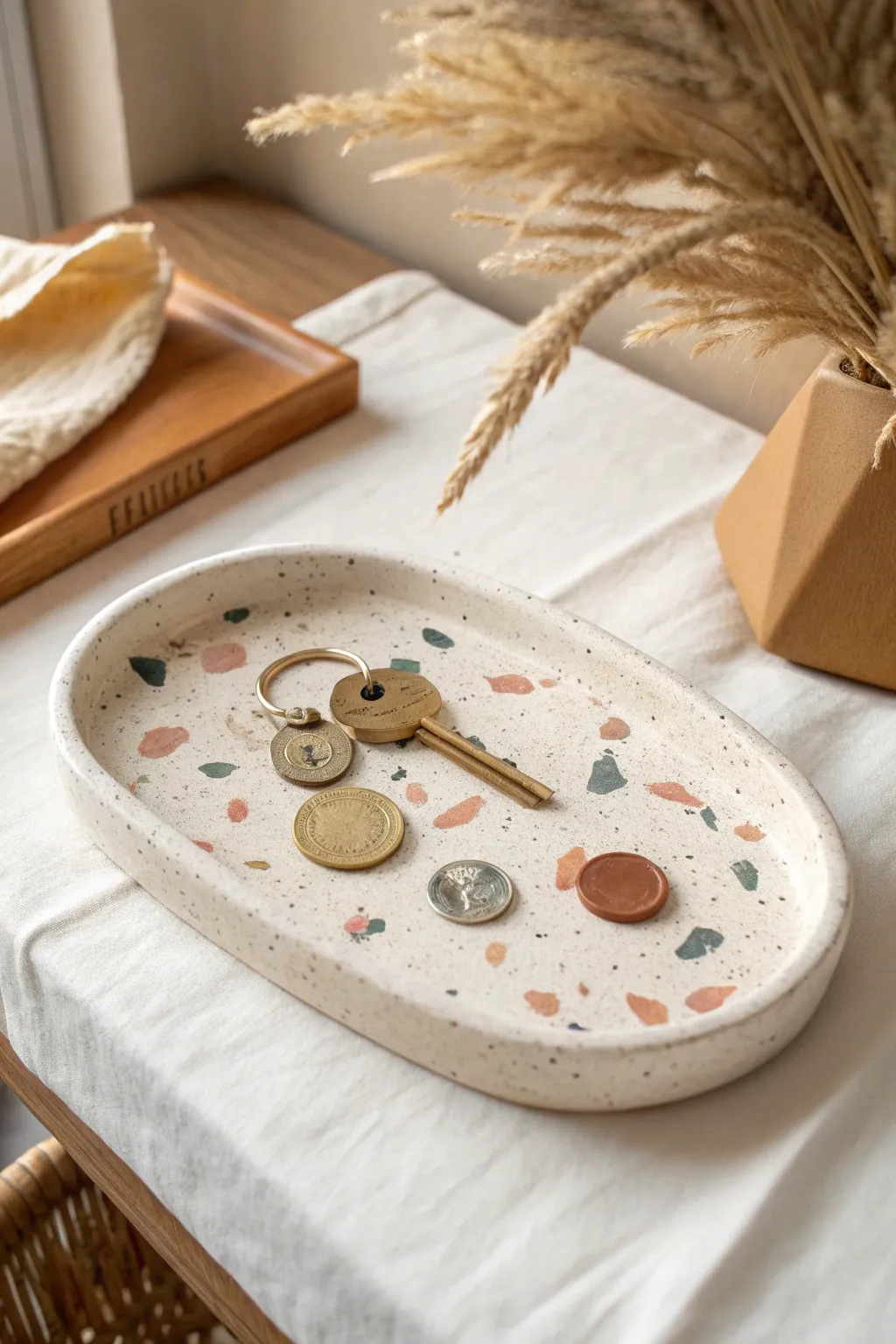 Terrazzo speckle clay trinket tray styled simply with keys and coins, calm minimalist charm.