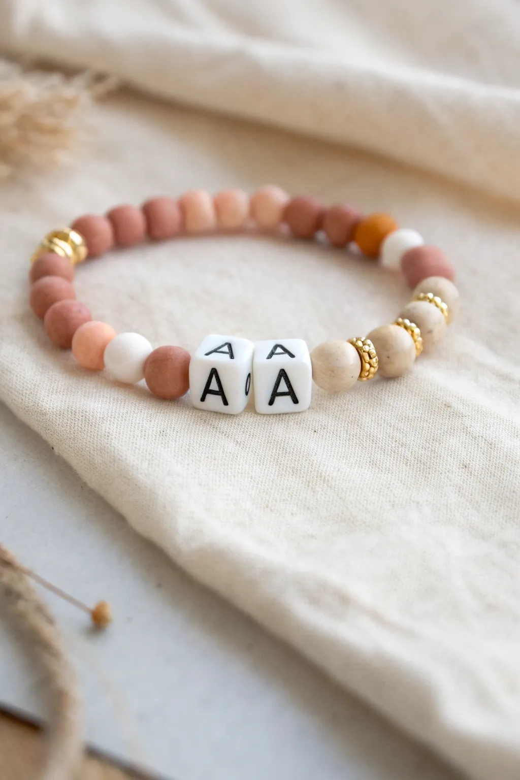 Sweet name-letter bracelet with balanced clay beads and tiny gold spacers, minimalist and chic.