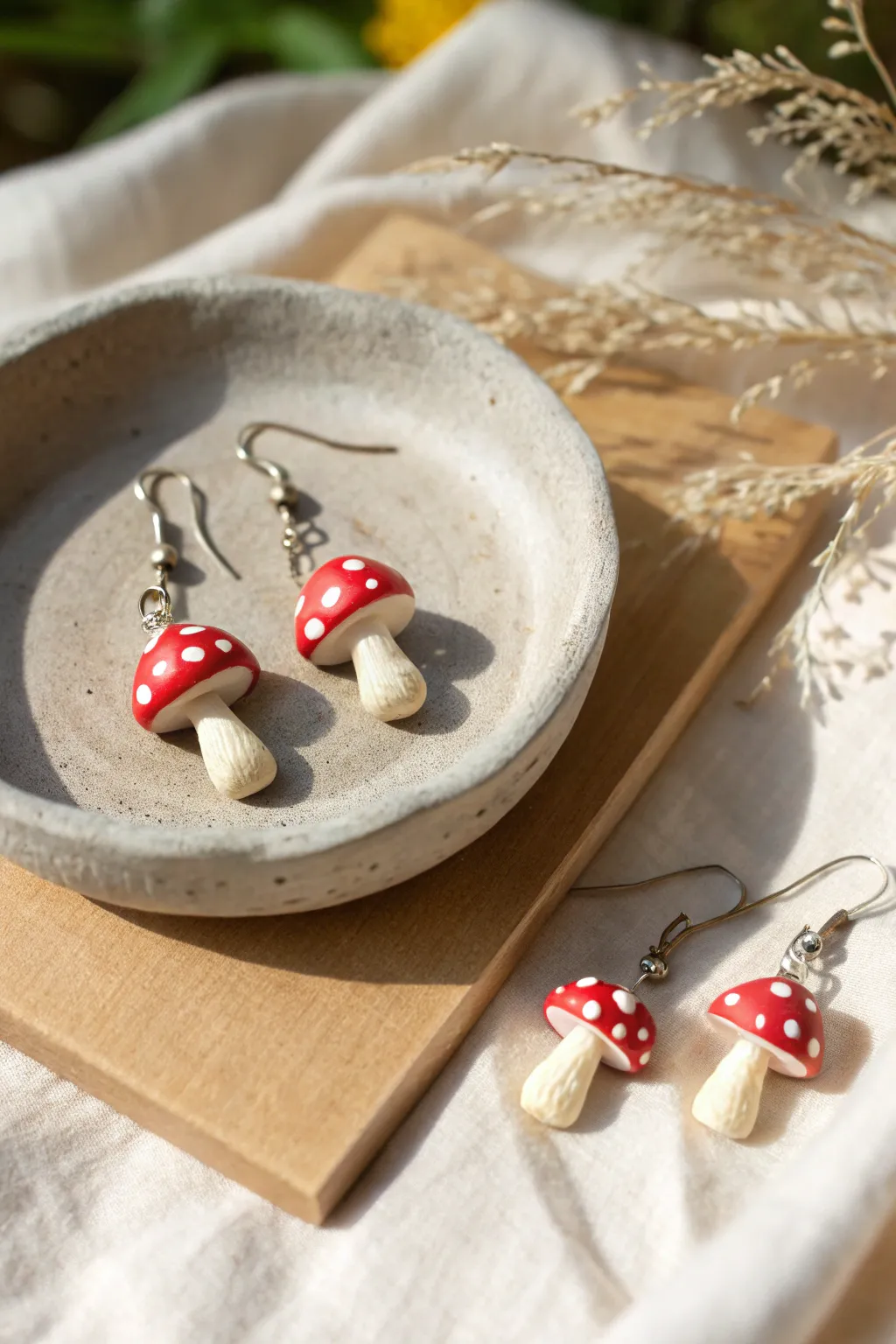 Tiny mushroom earrings set in classic red and dreamy pastels, styled in calm Scandinavian boho.