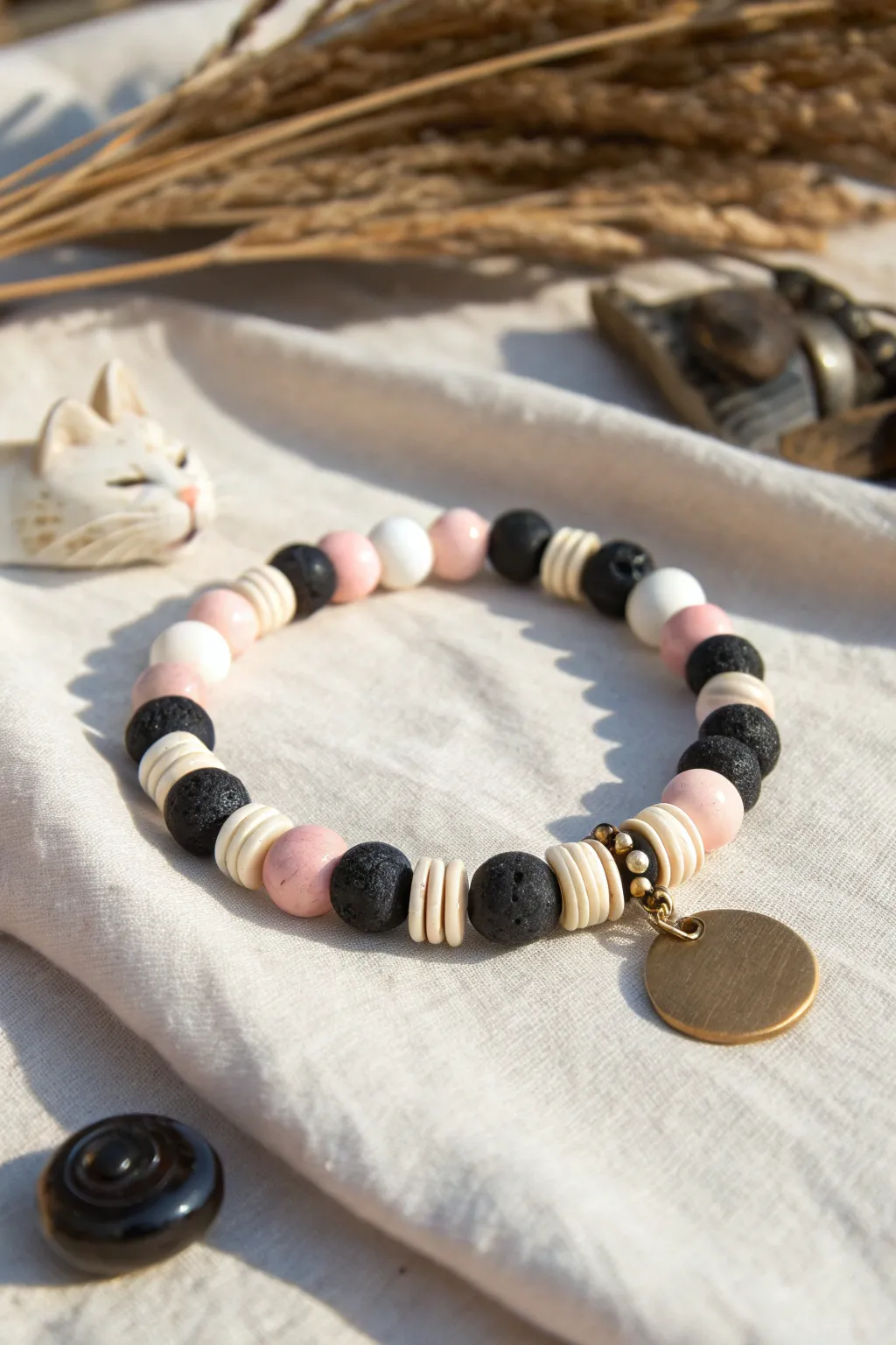 Black cat focal with blush clay disc beads for a sweet minimalist Halloween bracelet