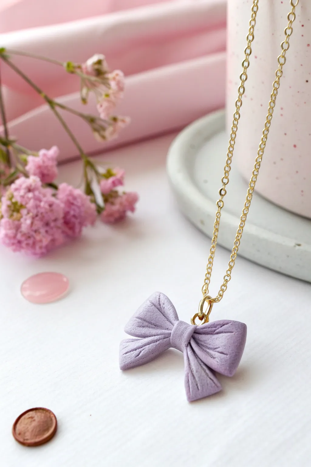 Pastel lilac polymer clay bow pendant on a delicate chain, sweet, minimal, and handmade.