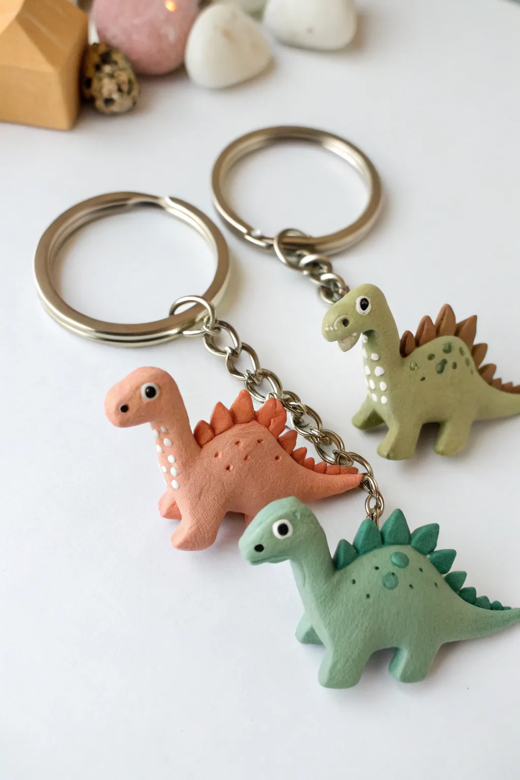 Tiny clay dinosaur keychain charms in clean color blocks, minimalist, cute, and handmade