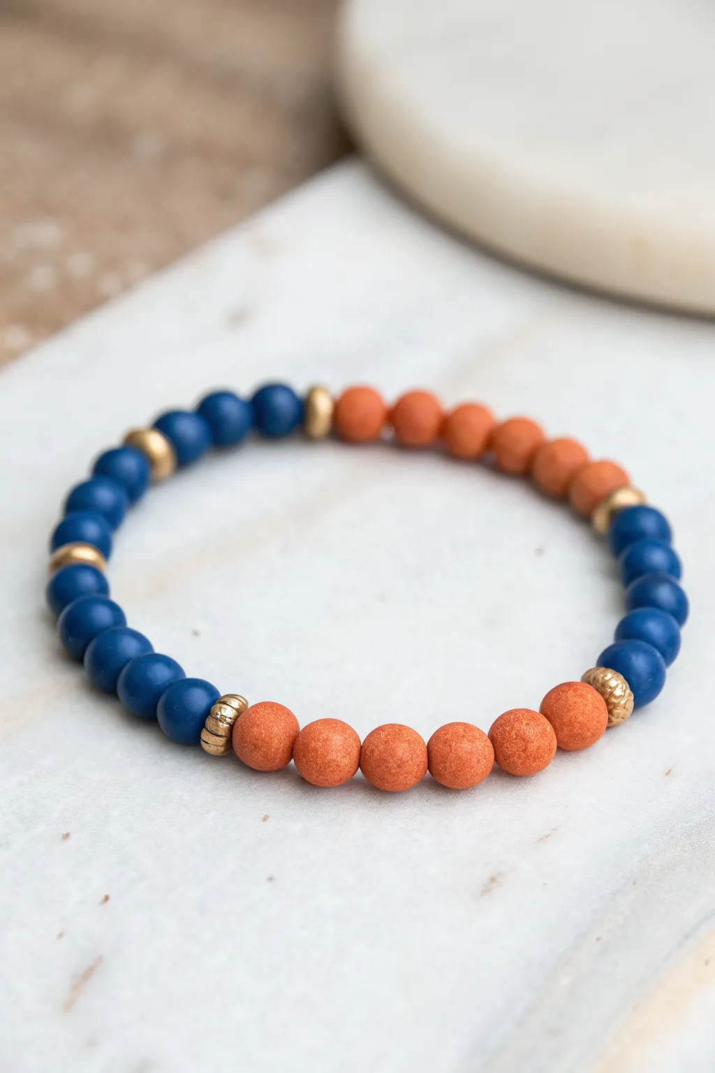 Bold blue + terracotta clay beads in an easy repeating pattern for a modern DIY bracelet.