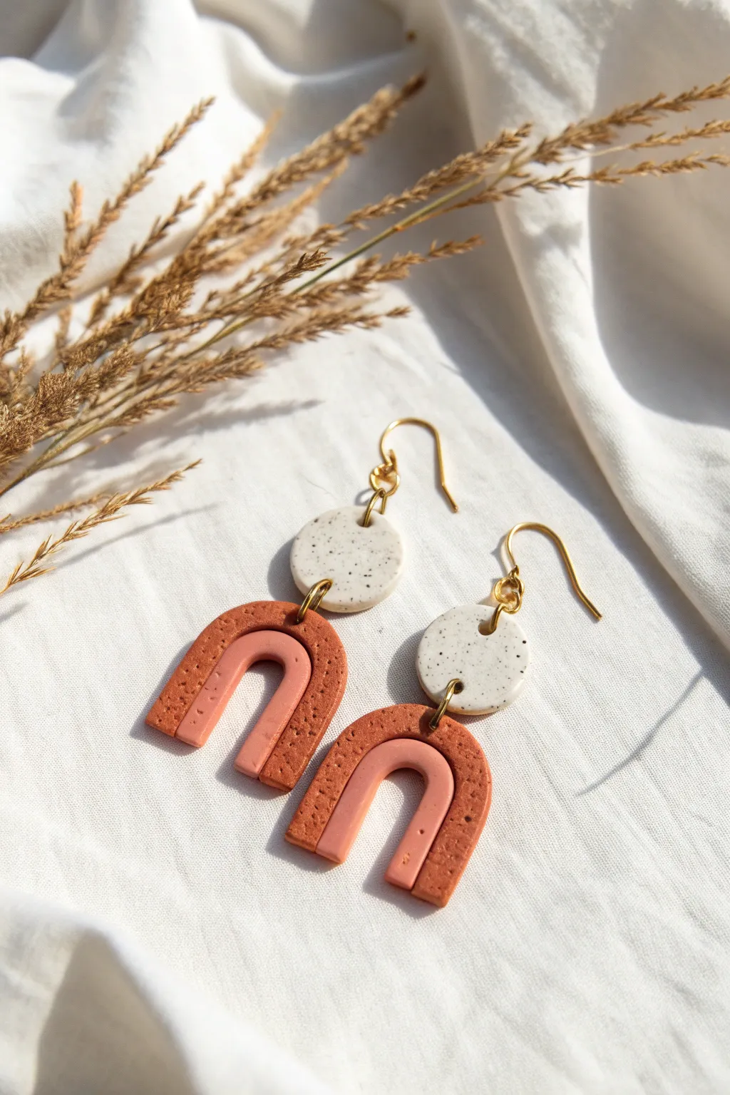 Minimalist polymer clay arches and circles in soft terracotta and blush, ready to wear.
