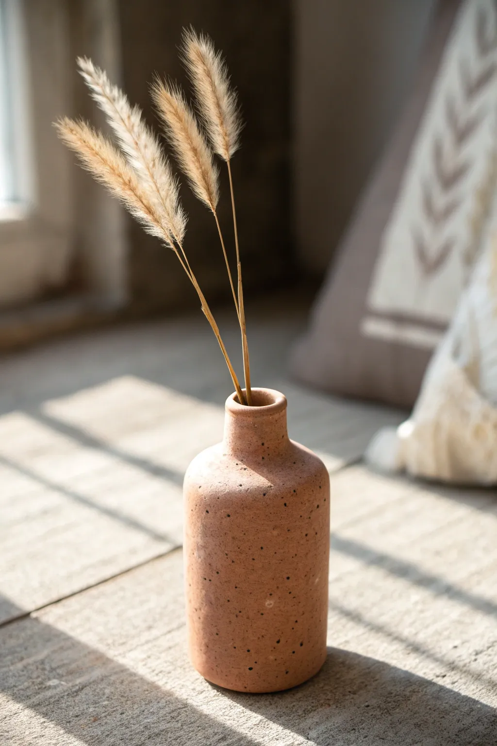 Simple handmade bud vase with dried stems, minimalist Scandinavian style and warm earthy contrast.