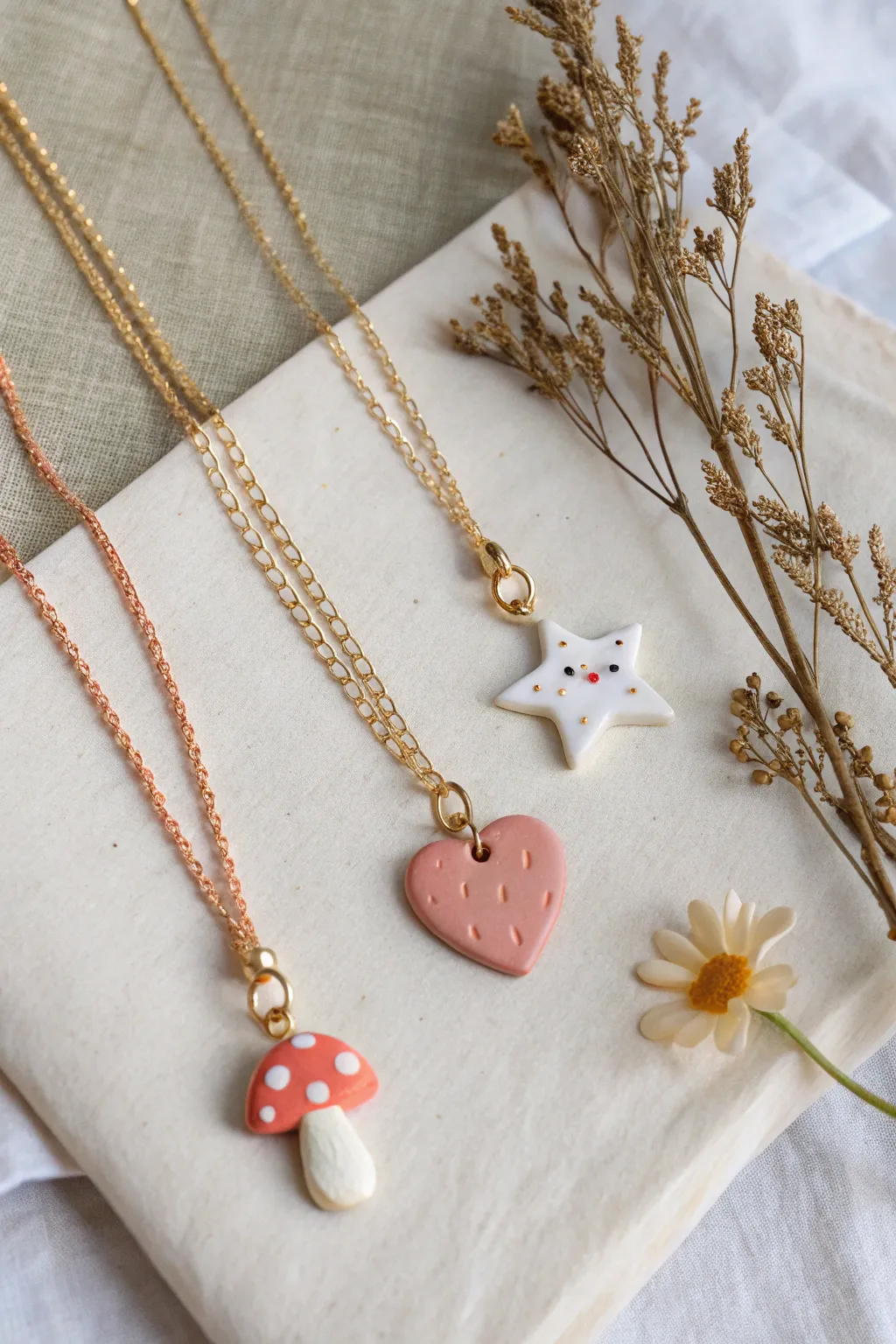 Sweet polymer clay pendant necklaces with heart, mushroom, and star charms in soft pastel tones.