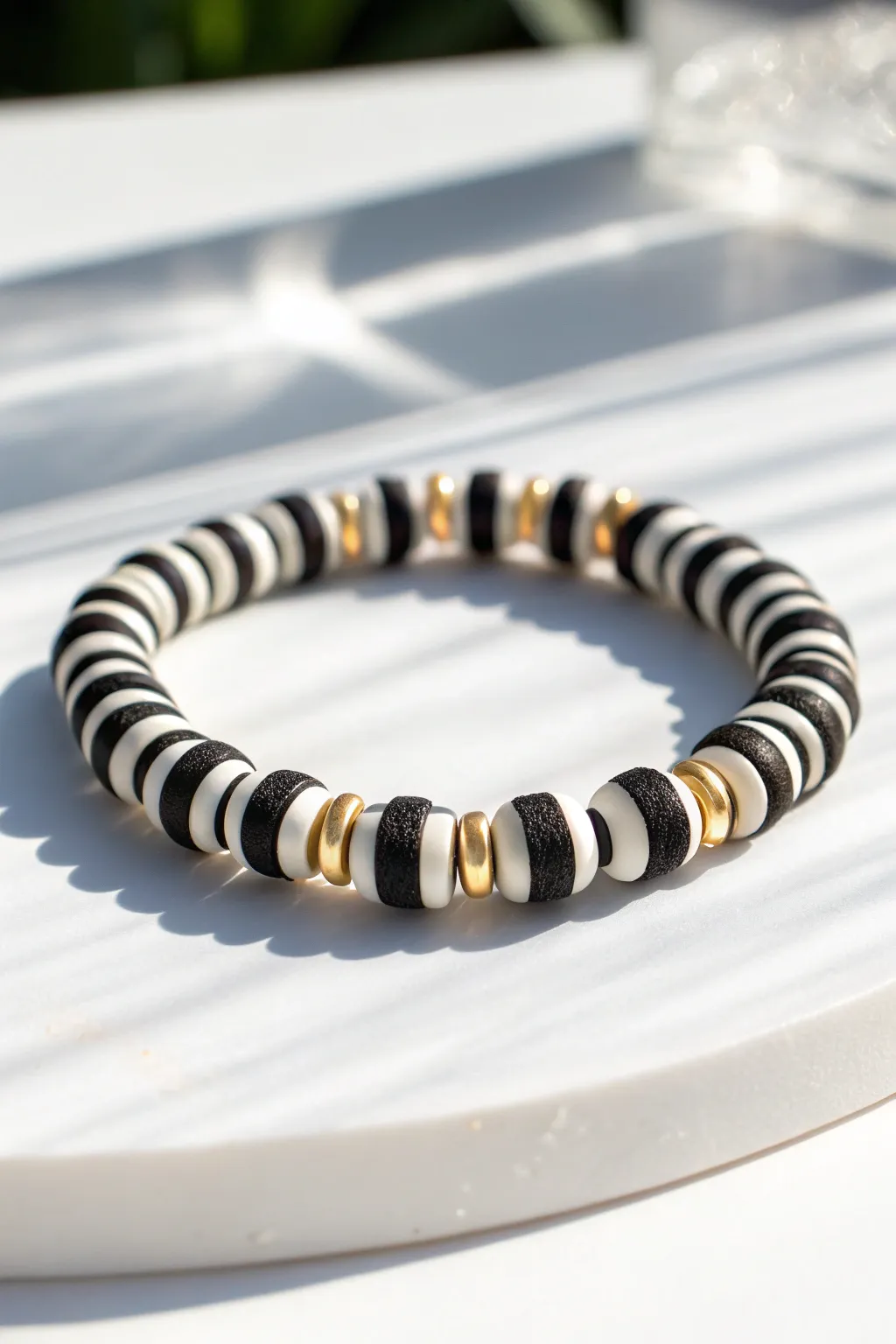 Bold black and white clay disc bead bracelet with subtle metallic spacers, minimal and chic.