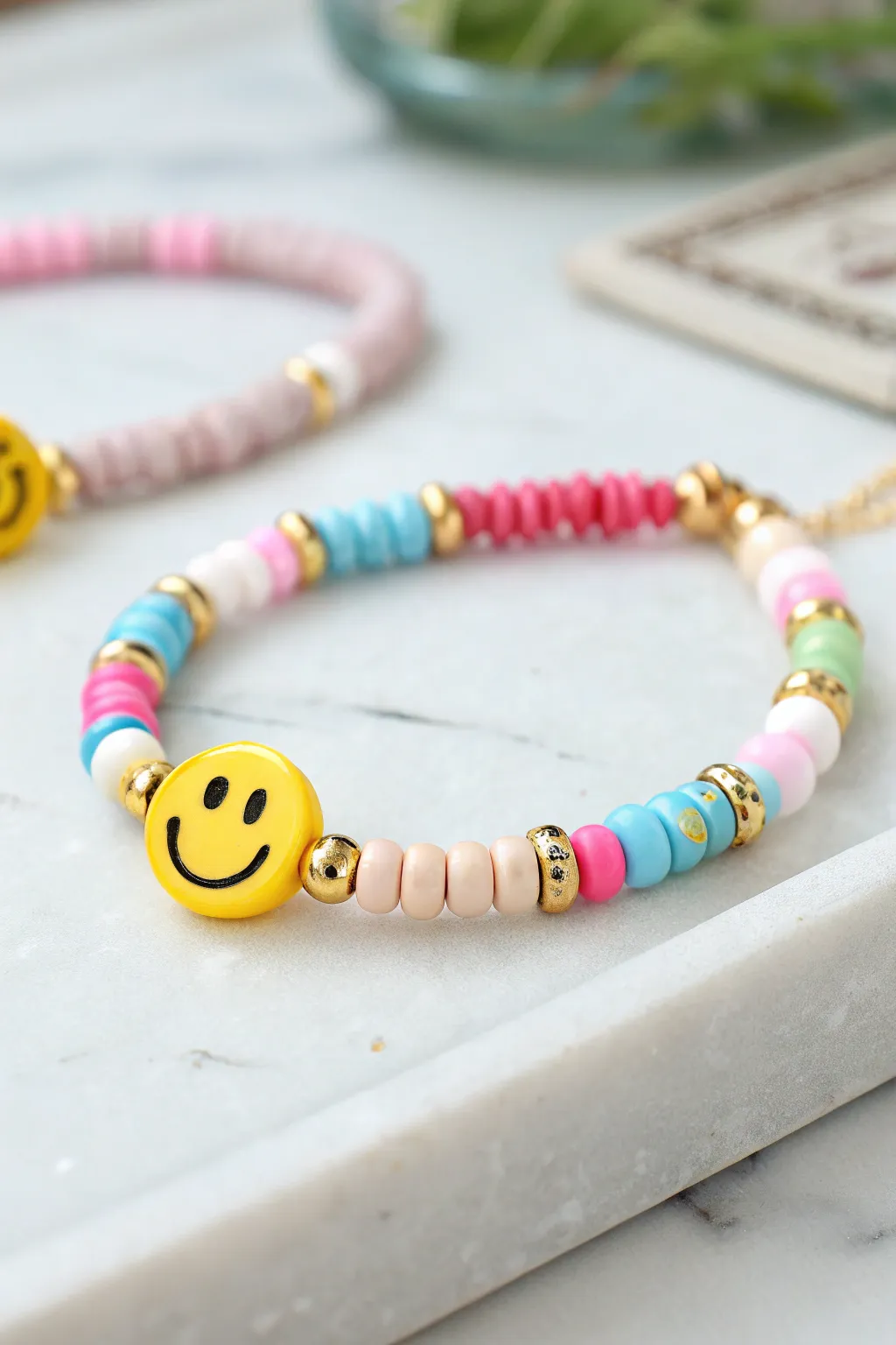 Bright heishi bead bracelet with bold smiley charm and gold spacers, perfect mini stack vibe.